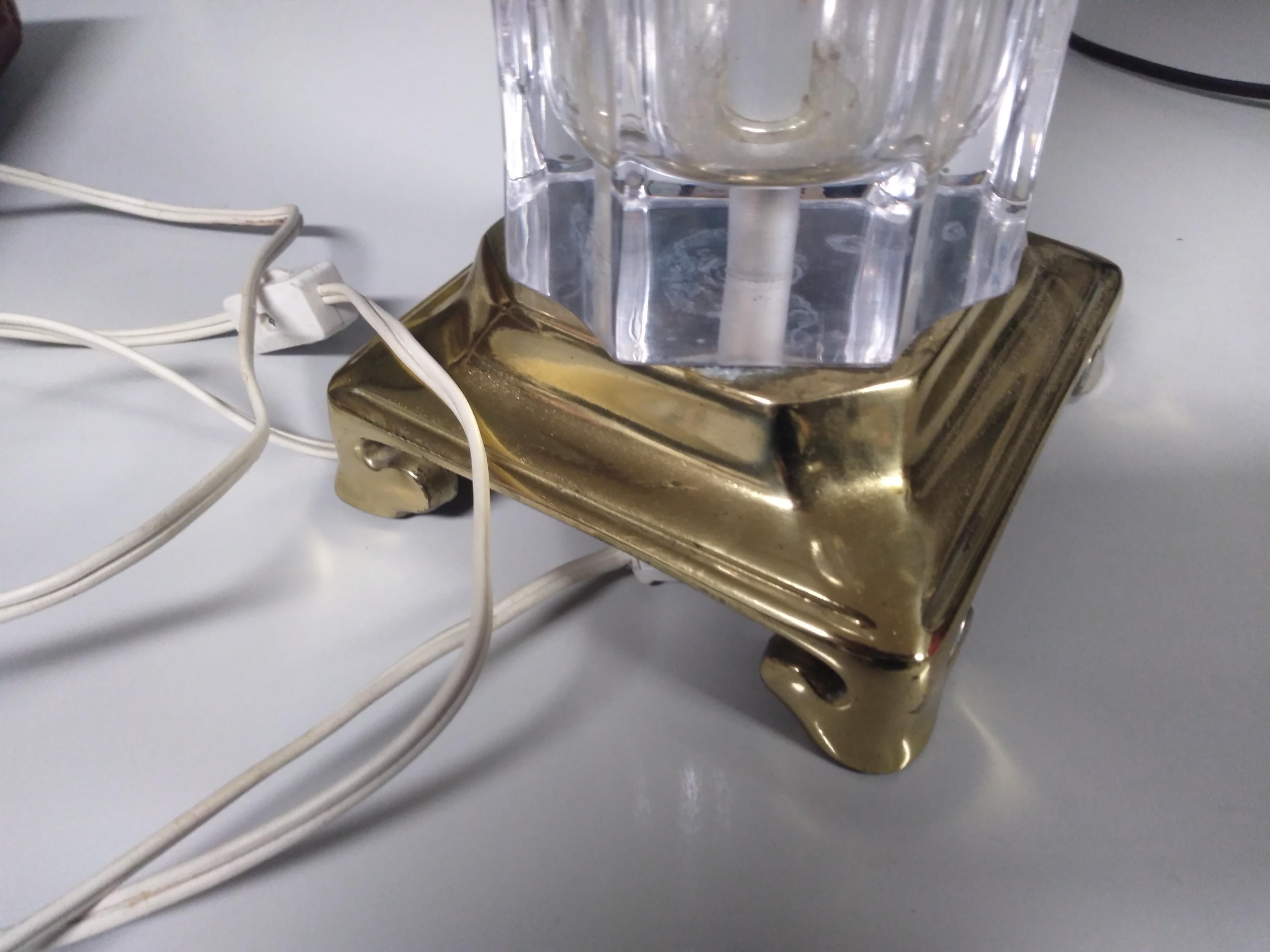 Voici une magnifique lampe de table en verre taillé avec une base en laiton. Il est éclairé par une lumière en forme de bougie.