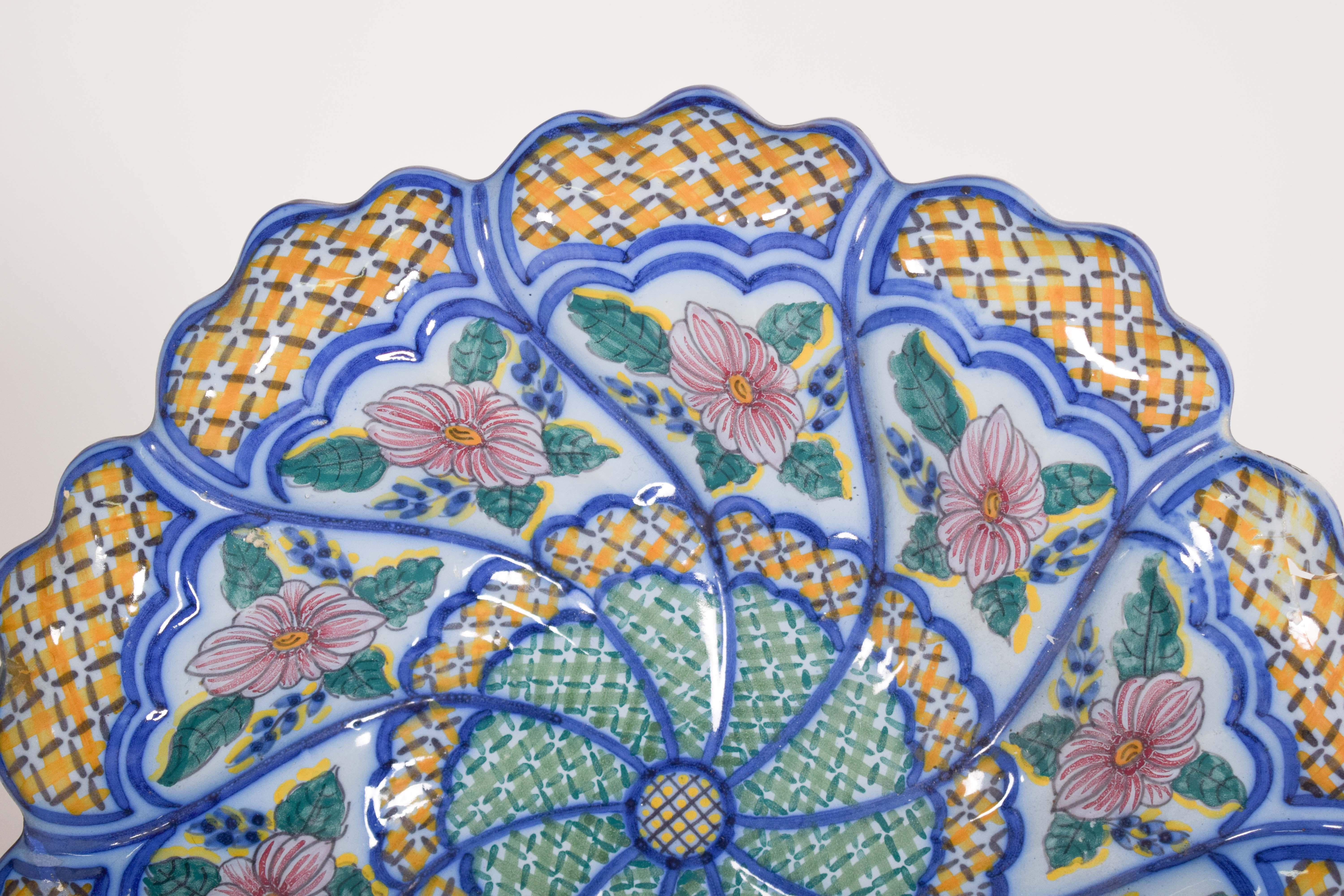 Assiette découpée, en faïence portugaise, Frutuoso, provenant des Statuts de Coimbra. Décoration polychrome avec des fleurs et des bourgeons stylisés se distinguant par l'explosion de couleurs vives et le dessin géométrique complexe.
La pièce a une