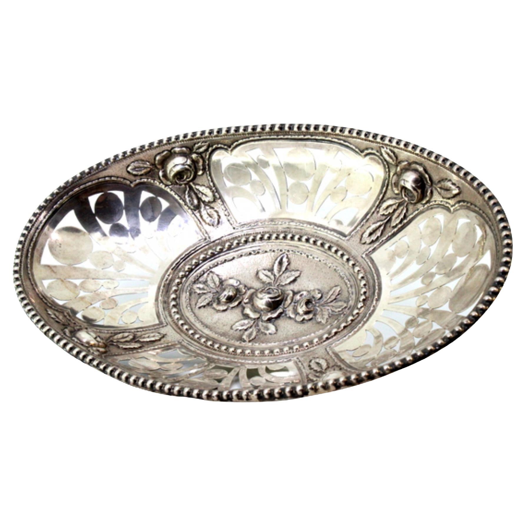 Cut-out silver fruit bowl with central floral relief and pearled rim