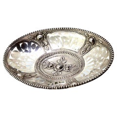 Cut-out silver fruit bowl with central floral relief and pearled rim