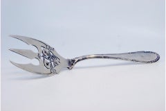 Cut silver fish fork with engraved tines and handle friezes