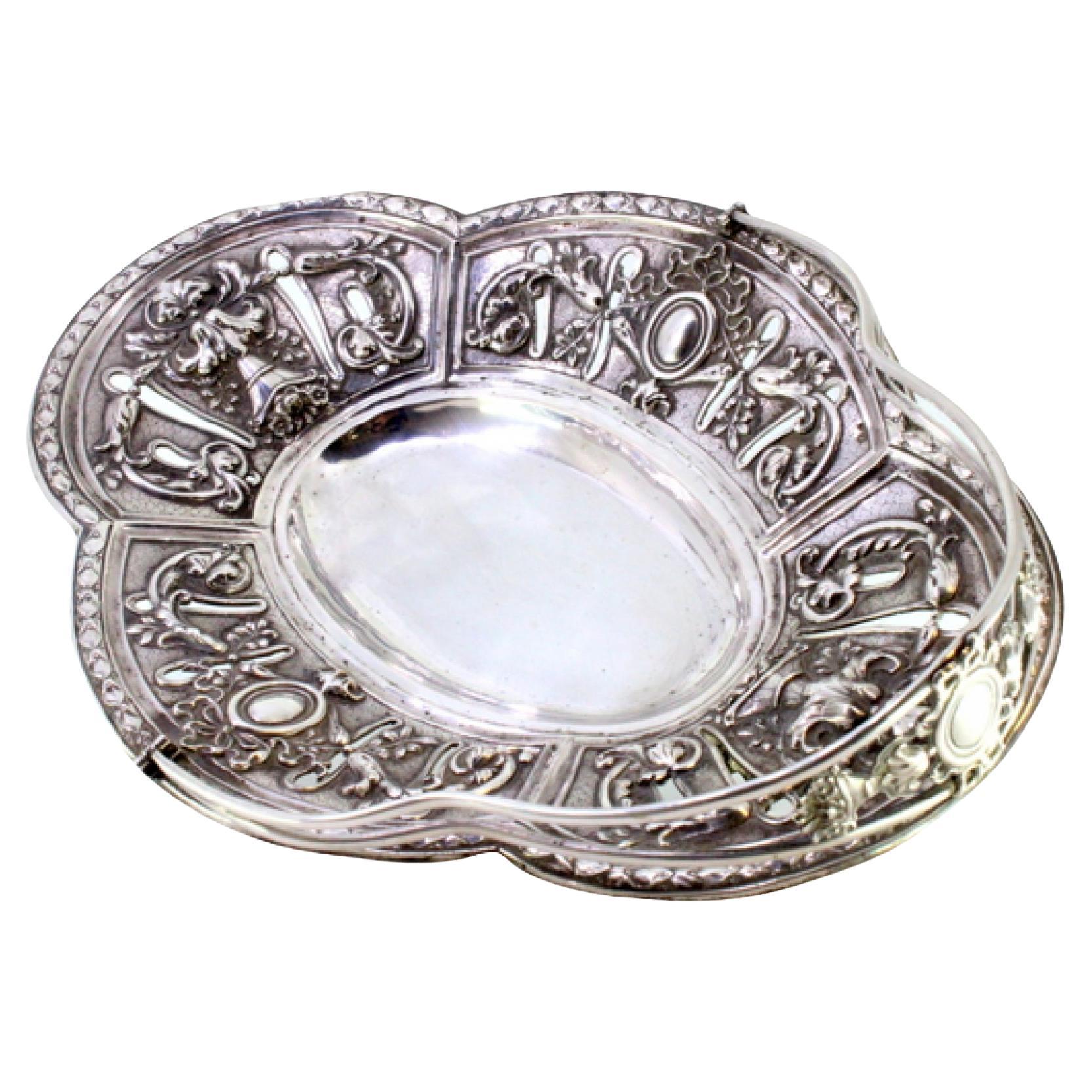 Cut silver fruit bowl with hinged handle and friezes on four openwork feet