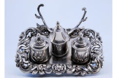 Cut silver inkwell with reliefs, three lidded tanks & bell