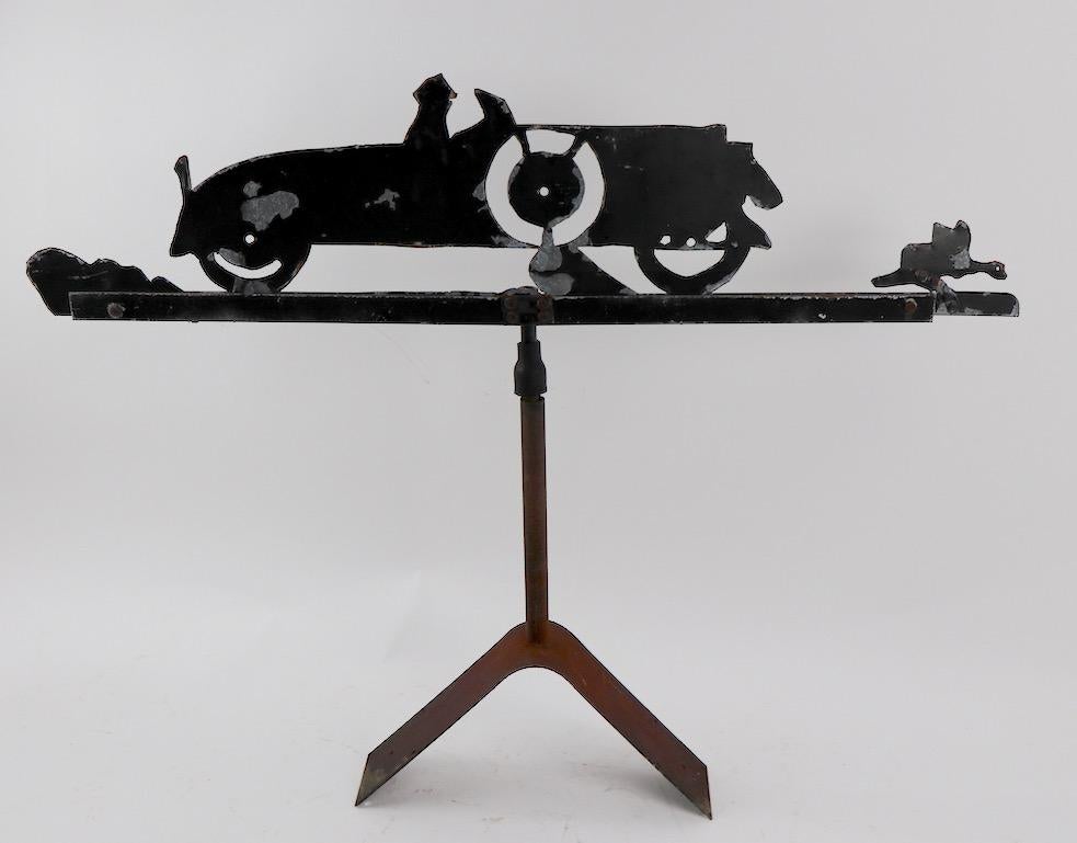 Charming Folk Art weathervane depicting a luxury car chasing a duck. Original roof mount stand included, wind directional elements missing. Nice sculptural form, early 20th century. Period item.
