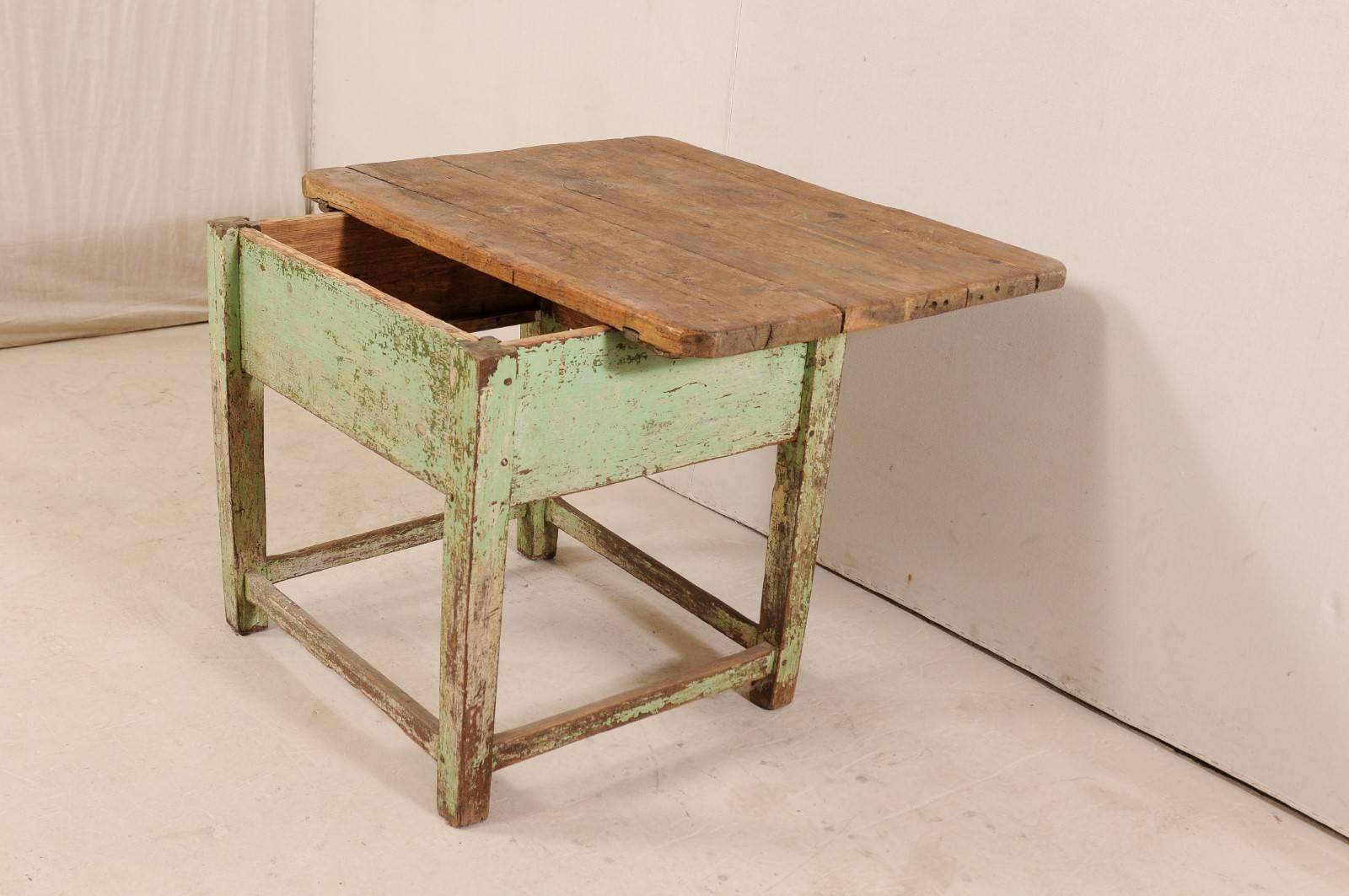 Table européenne du XIXe siècle avec plateau coulissant. Cette table européenne ancienne est rustique et accueillante avec son plateau en bois naturel magnifiquement vieilli, un contraste agréable avec la base qui a des restes de sa vieille peinture