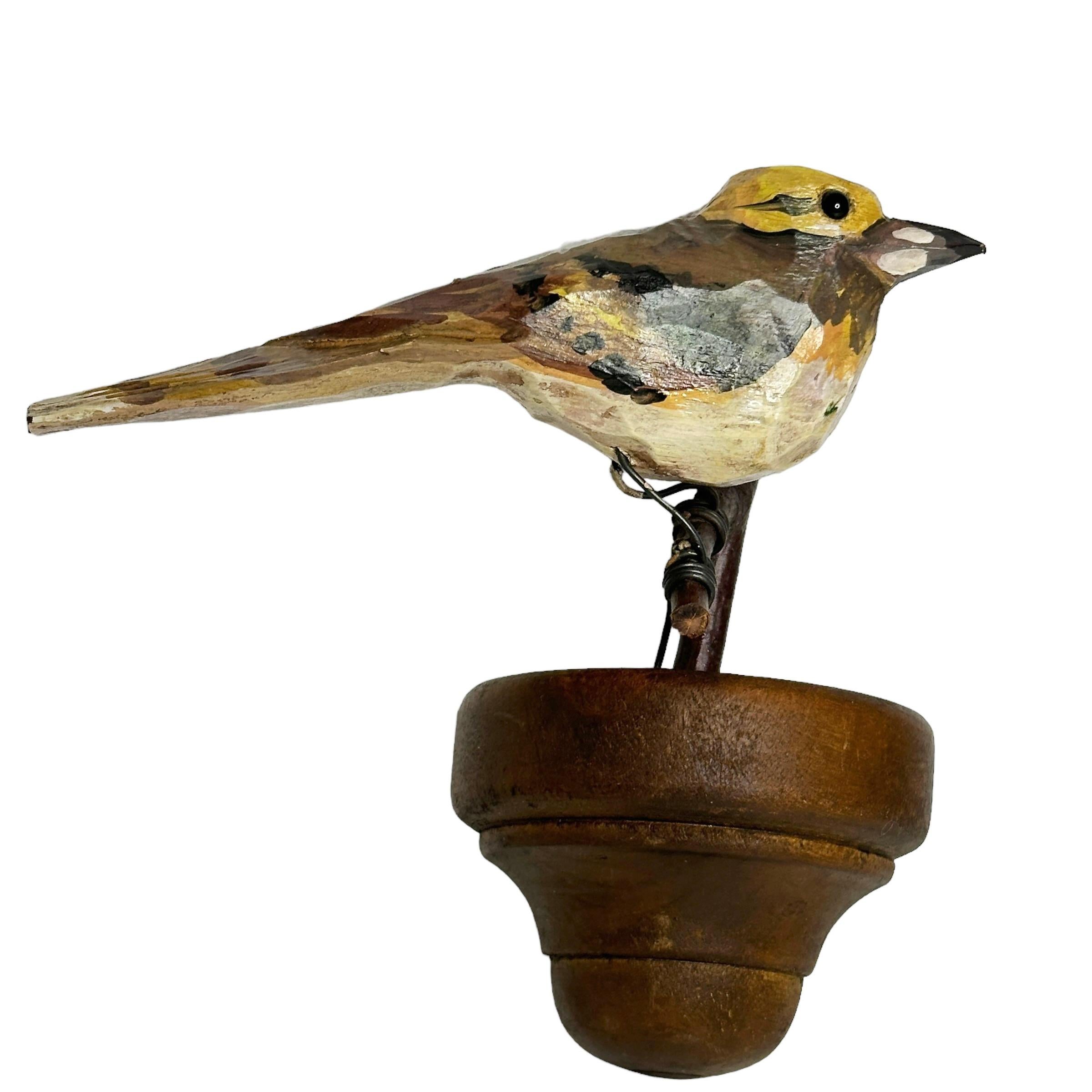 Ein schöner kleiner geschnitzter Holzvogel aus dem 20. Jahrhundert, der auf einem Holzständer zum Aufhängen montiert ist. Die Tradition dieser in Österreich 