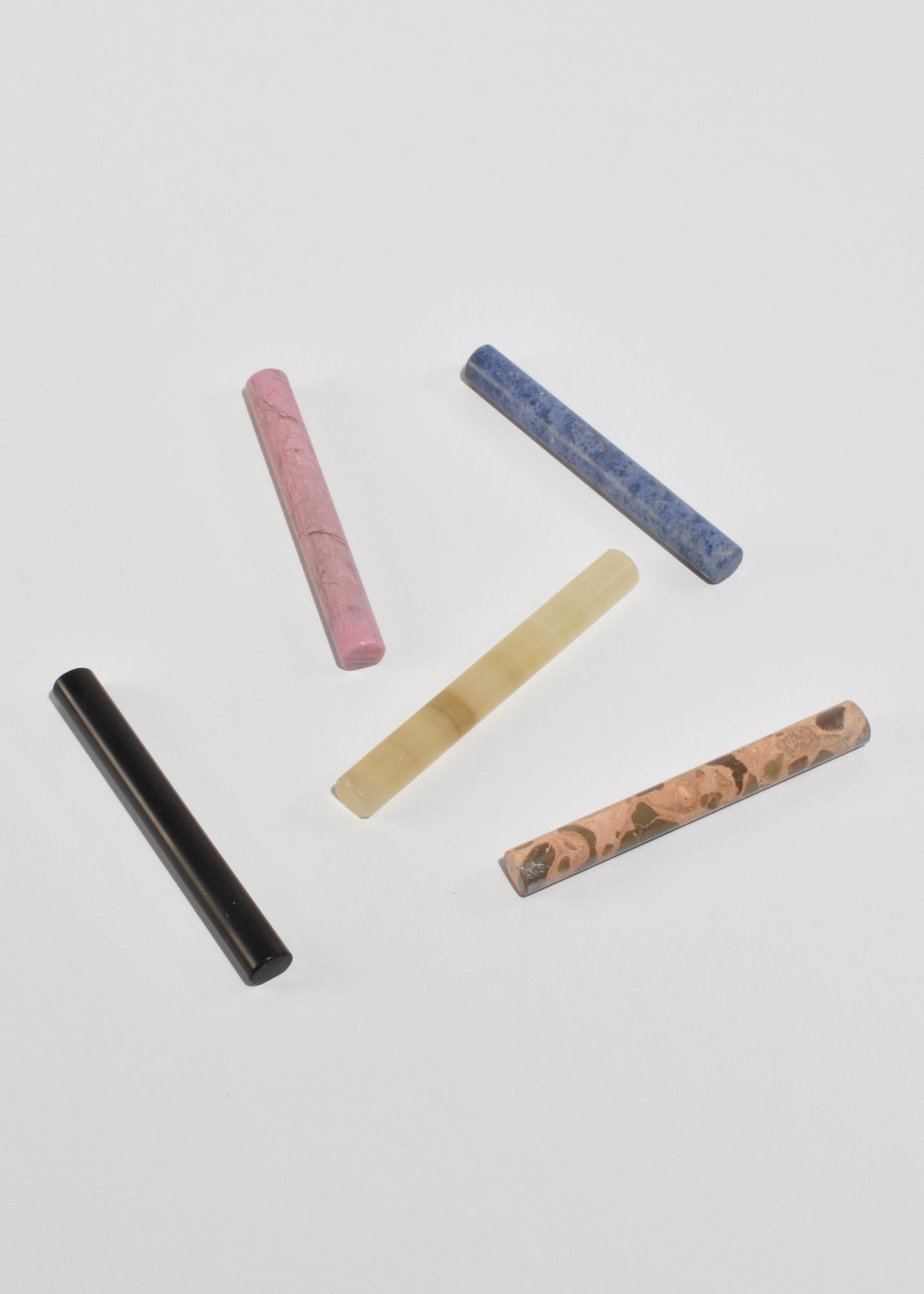 A set of five cutlery rests in mixed stones: black onyx, pink rhodonite, onyx, leopardite, and blue dumortierite. Designed by Casa Shop and handcrafted in Perú.

Subtle variations in pattern are a hallmark of its hand-finished nature, crafted from