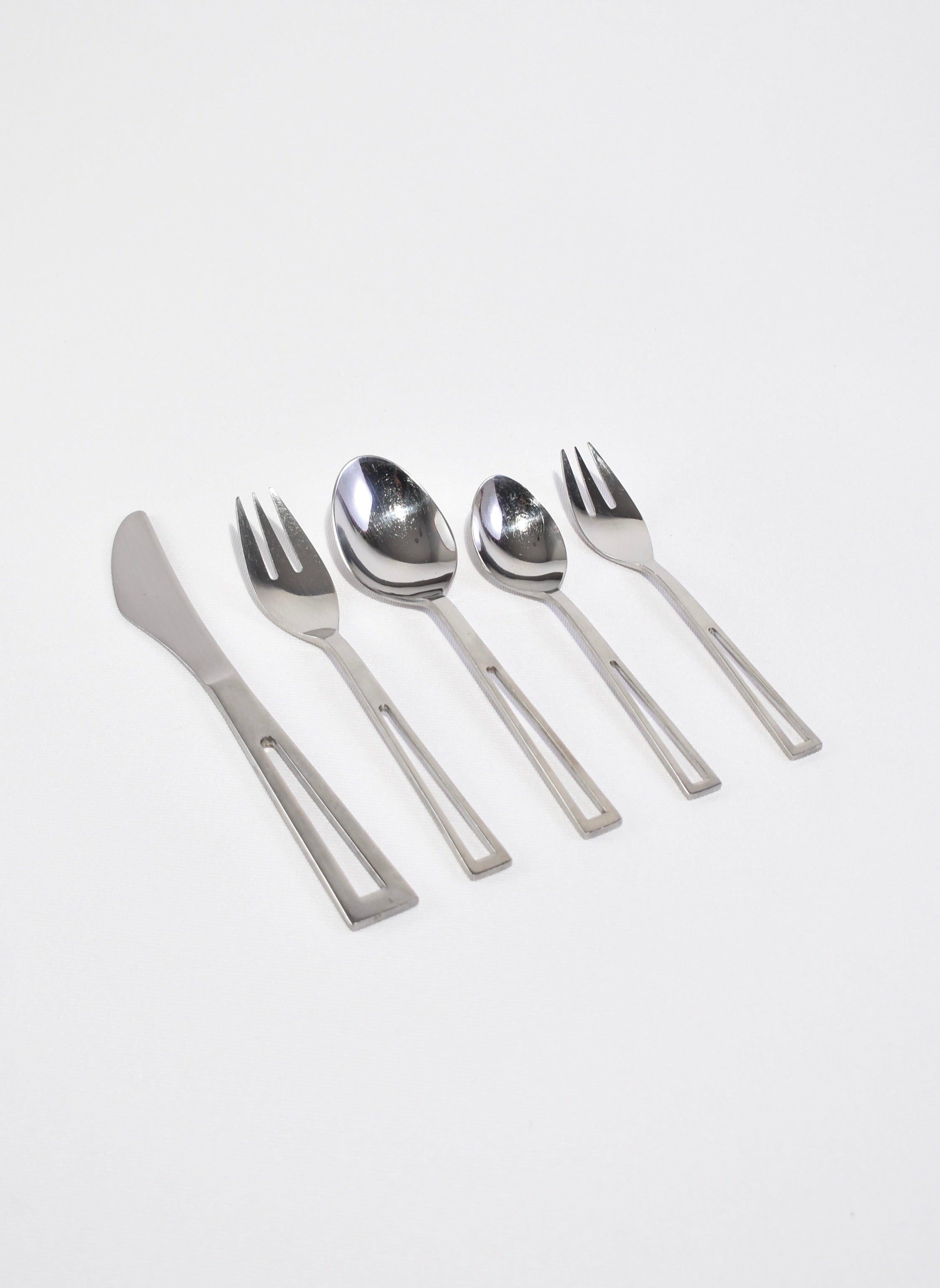 Vintage, stainless steel flatware set of five pieces (knife, two spoons, two forks) with cutout handle detail. Signed Supreme Cutlery, Made in ?Japan.?

Purchase includes one set of five pieces.
 