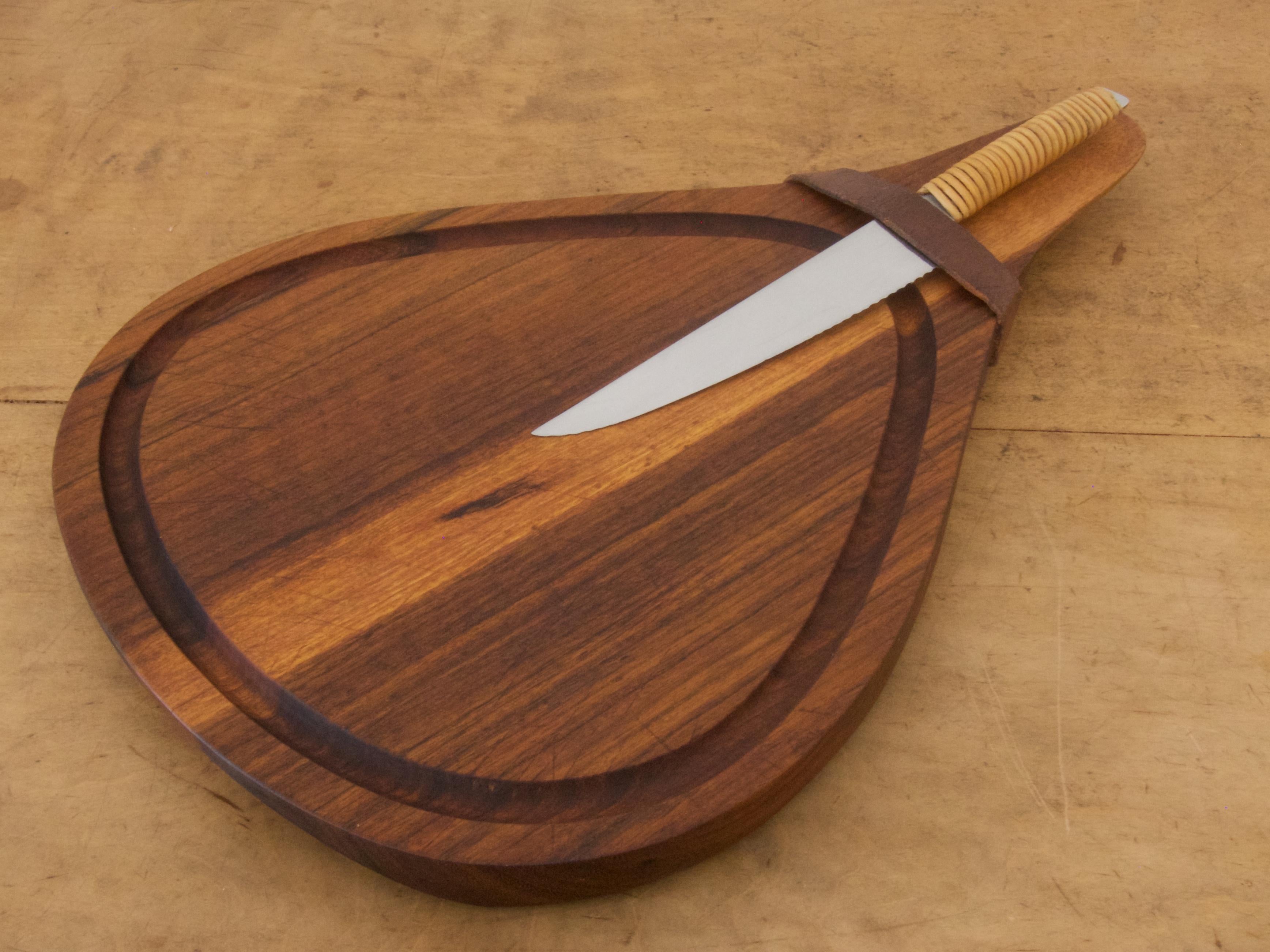 Beautiful cutting board with a knife designed in the 1950s by Carl Auböck

Nutwood board with a leather strap, stainless steel knife with a wicker handle
The knife is marked with the AMBOSS logo, AUBÖCK, STAINLESS and MADE IN