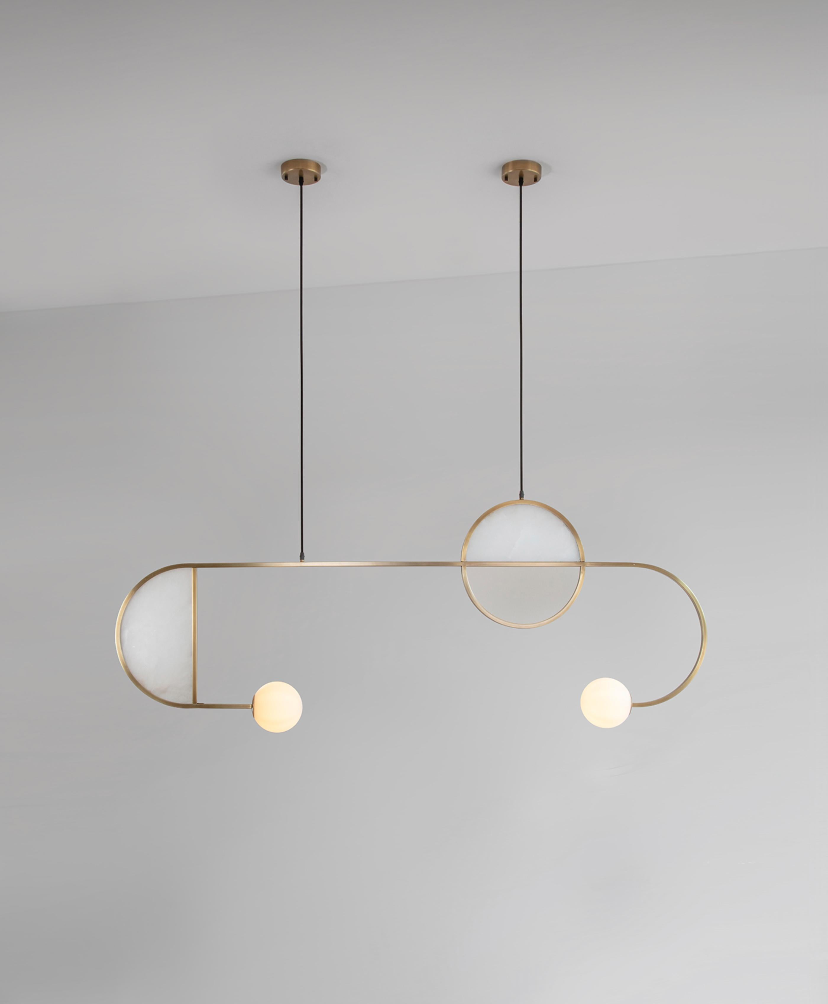 Cutting Edge Pendant Lamp by Square in Circle
Dimensions: H 135 x W 16 x D 177 cm
Materials: Brushed brass finish, alabaster marble, opaque glass globe.

A statement pendant light with a thin metal frame, marble panels inserted into semi-circles and