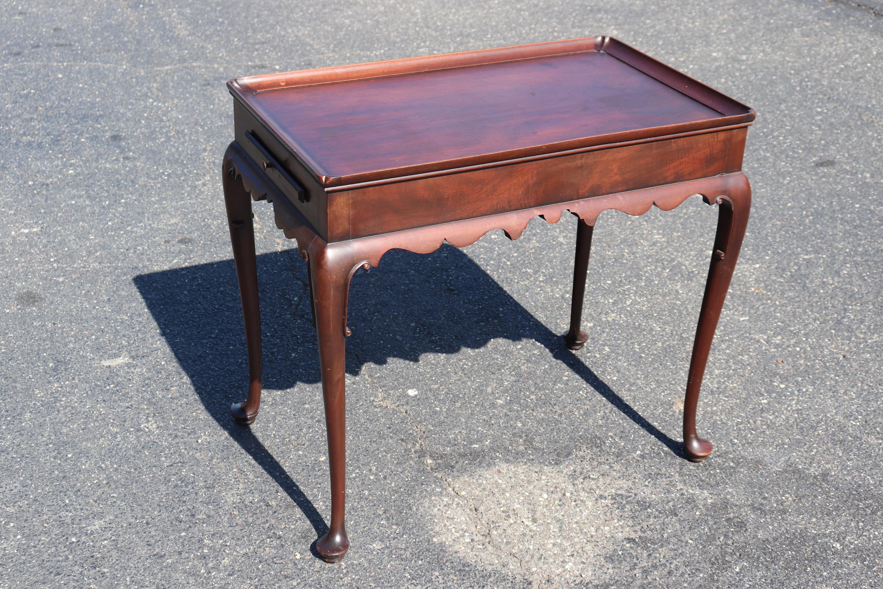 This is a fine quality solid mahogany Kittinger tea table in the Colonial Williamsburg line. The table dates to the 1950s and is entirely original. The table is in good vintage condition and will show signs of age and use on the finish. Measures 29