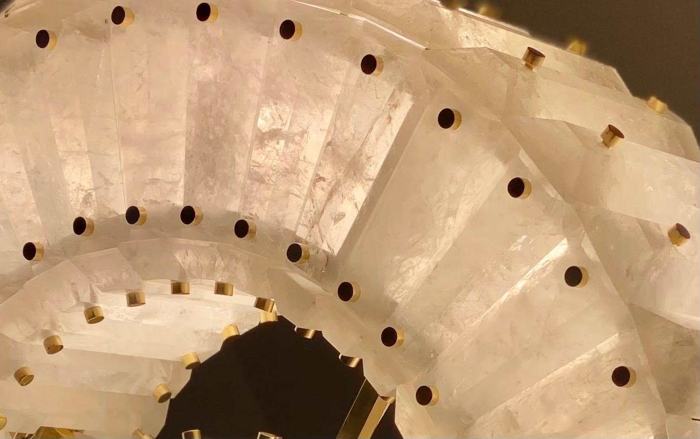 Lampadario rotondo in cristallo di rocca con sezione centrale e decorazione con chiodi in ottone. Pannelli di cristallo di rocca finemente intagliati e sfaccettati installati lungo la circonferenza del cerchio.

L'altezza complessiva può essere