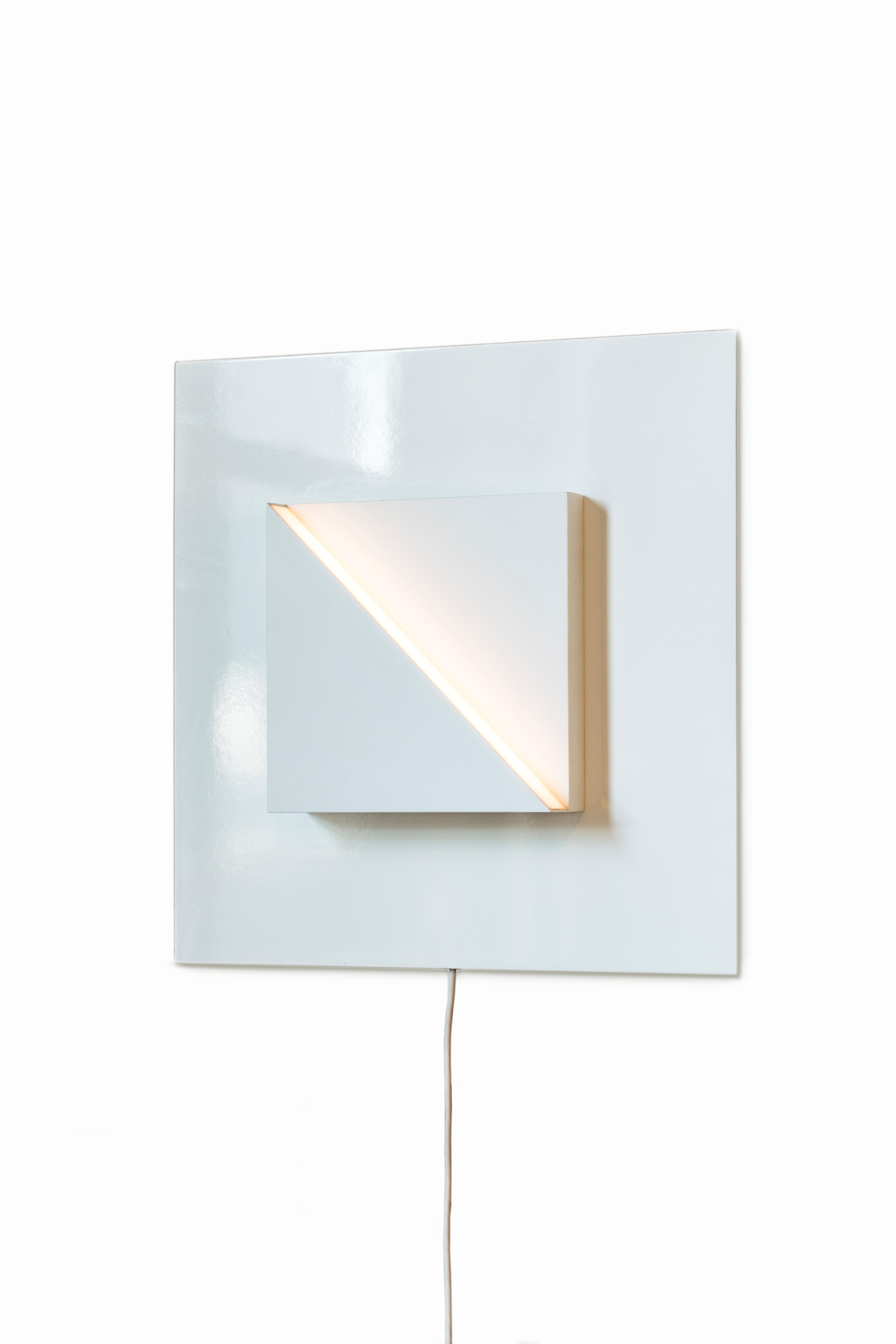 Part of the Cycladic Series, exploring the power of architecture brought to small scale. The framed square sconce illuminates the purity, symbolism and intimate power of elemental geometric forms expressed in both nature and our manmade world. A