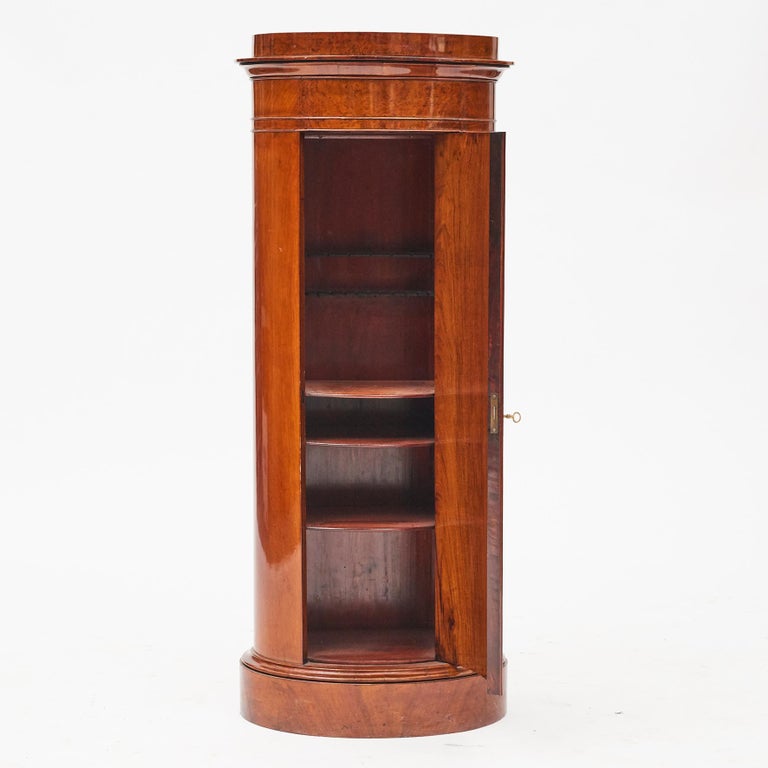 Cylinder burl walnut pedestal cabinet. Late empire. Oak beautifully veneered with walnut. A large front door that opens to reveal a set of four shelves. Copenhagen, 1830-1840.