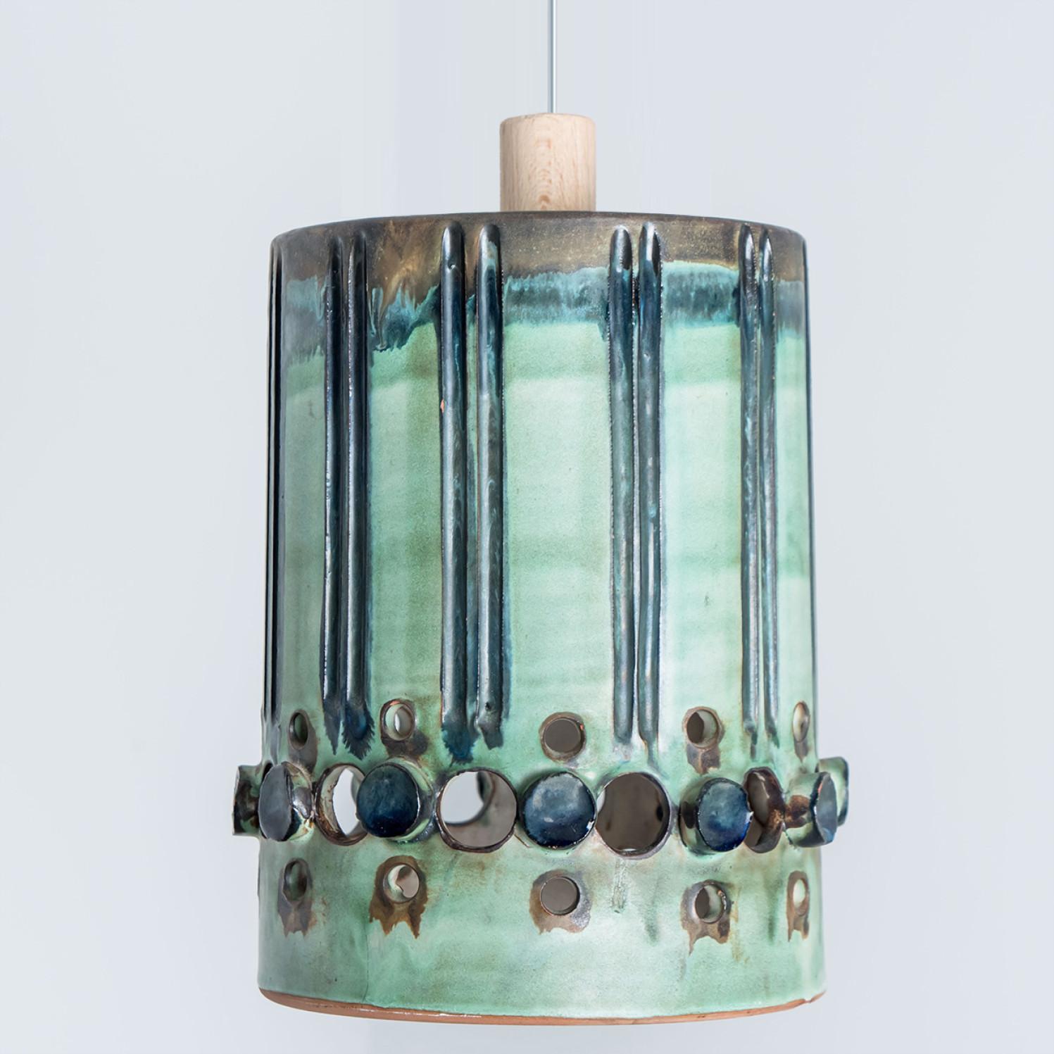 Stunning round hanging lamp with an unusual cylinder-like shape, made with rich colored green and turquoise ceramics, manufactured in the 1970s in Denmark. We also have a multitude of unique colored ceramic light sets and arrangements, all available