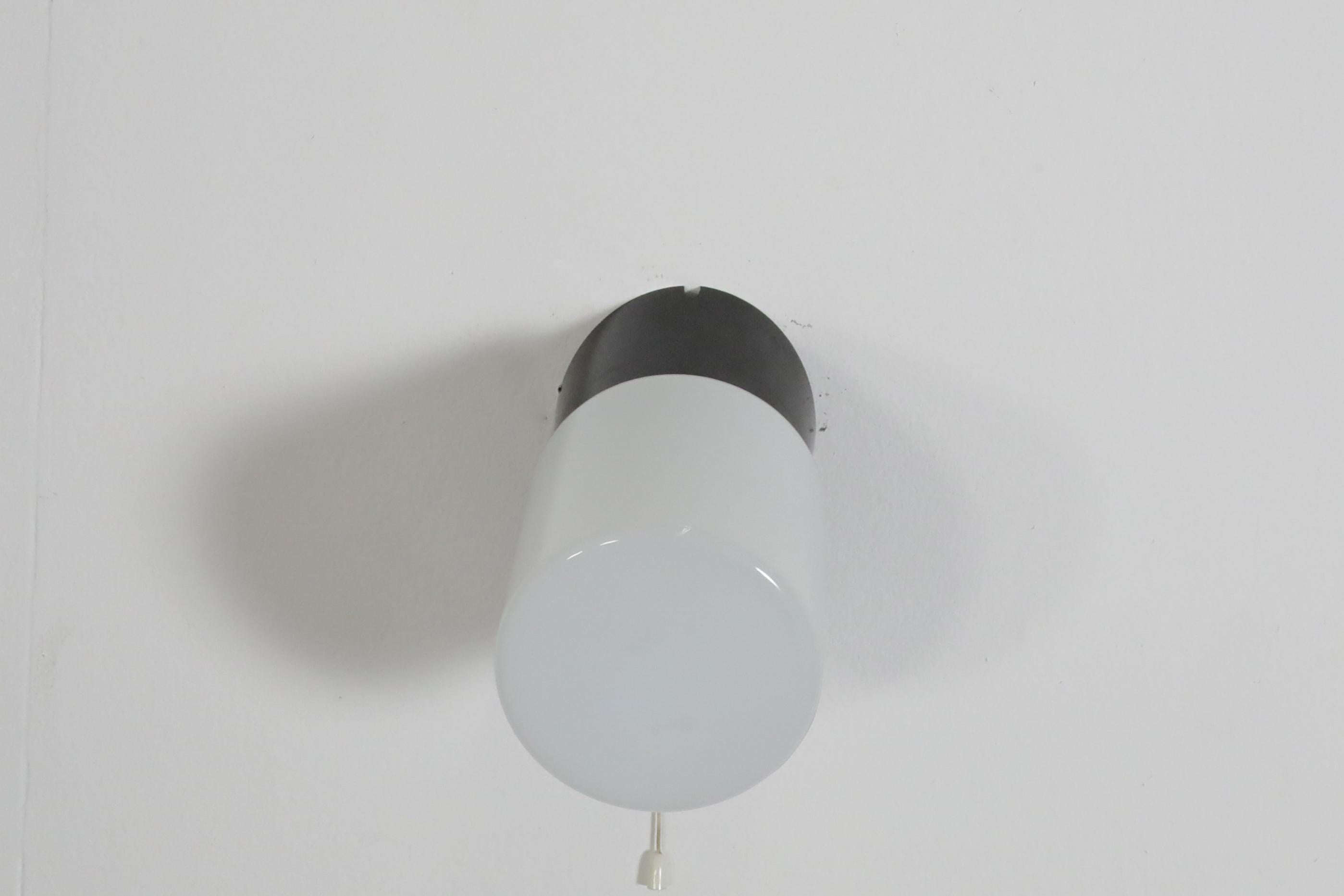 Milieu du XXe siècle Applique cylindrique en verre dépoli avec base en bakélite noire et interrupteur à cordes en vente