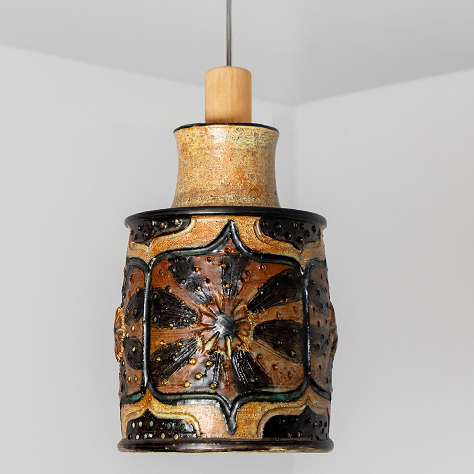 Stunning round hanging lamp with a cone-like shape, made with rich orange and green colored brown ceramics, manufactured in the 1970s in Denmark. We also have a multitude of unique colored ceramic light sets and arrangements, all available in the