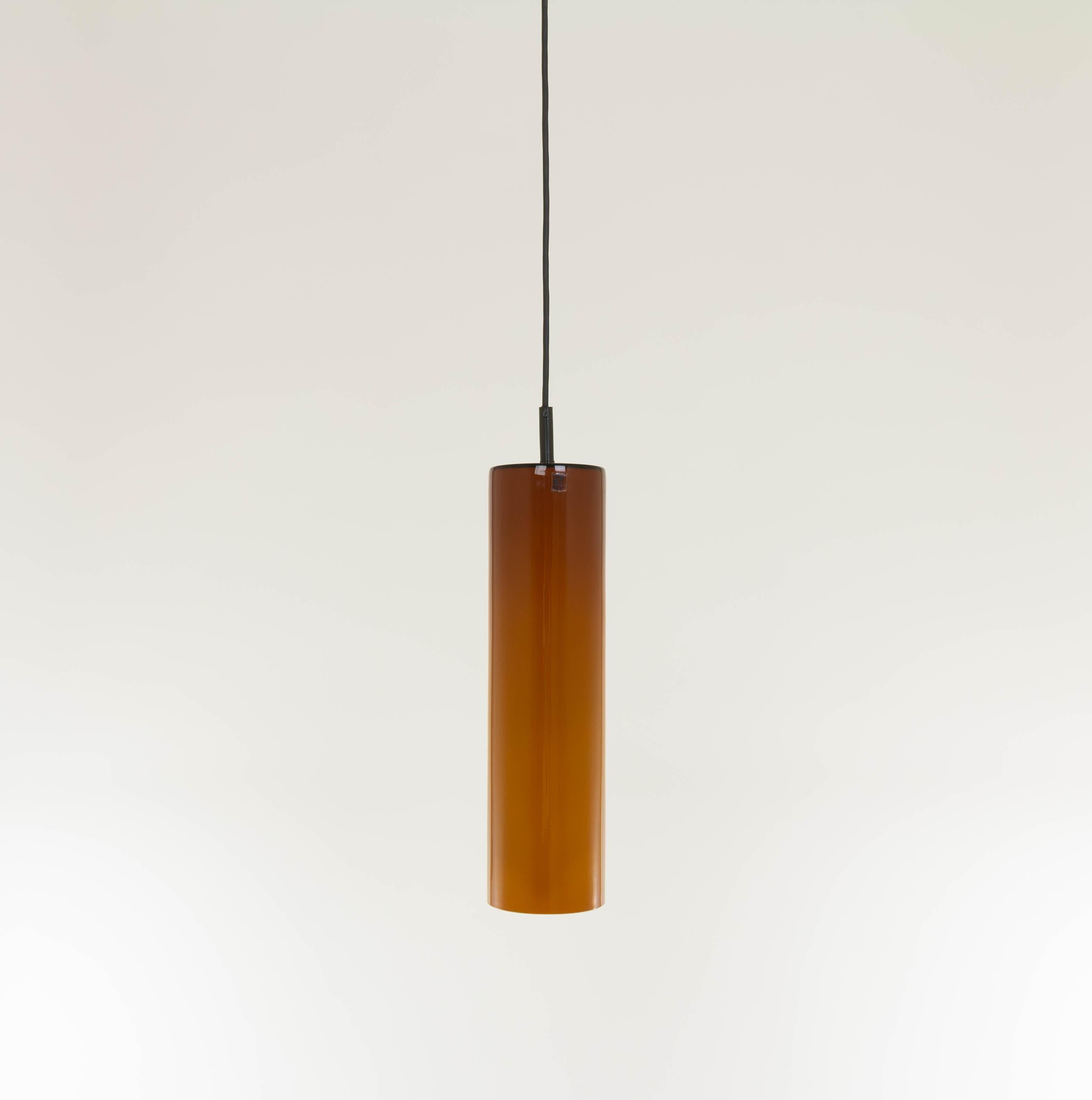 Pendentif de forme cylindrique de couleur ambre, conçu et produit par le spécialiste du verre Venini.

Ce modèle est conçu dans les années 1950, mais il s'agit d'une production plus récente.

La lampe est en parfait état car elle n'a jamais été