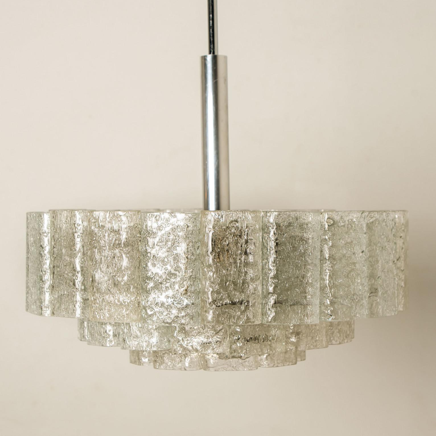 Fantastico lampadario a tre livelli della metà del secolo scorso di Doria Leuchten Germany. Prodotto intorno al 1960.
Tre anelli di cilindri in vetro di Murano sospesi da un apparecchio con dettagli in ottone. Di qualità pesante e in ottime