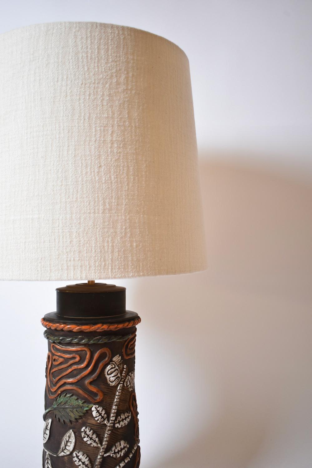 Cylindrical stoneware lamp base with relief decoration of spirals and foliage. France, 1960s.