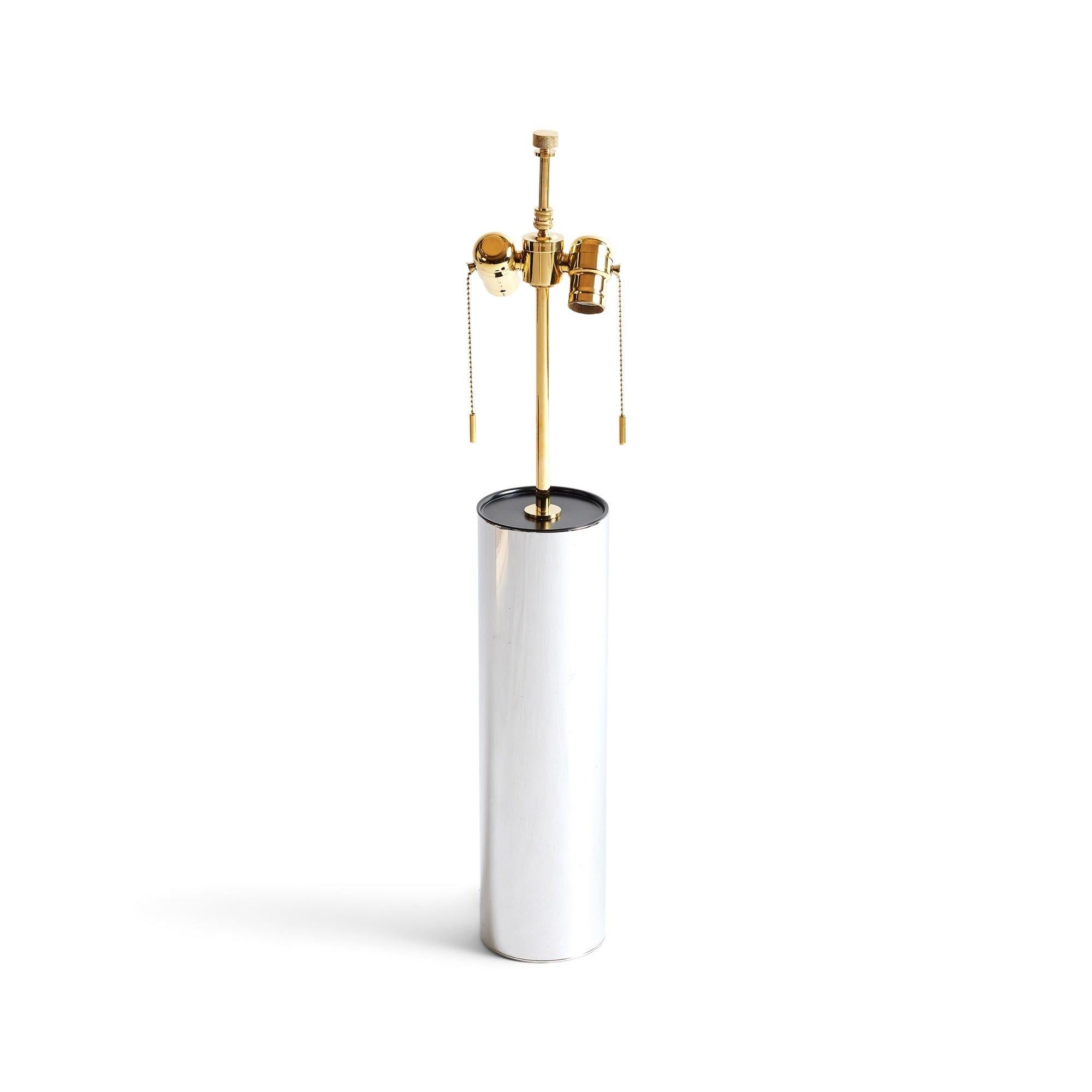 Lampe de table originale et sobre, dotée d'une base cylindrique en métal poli.