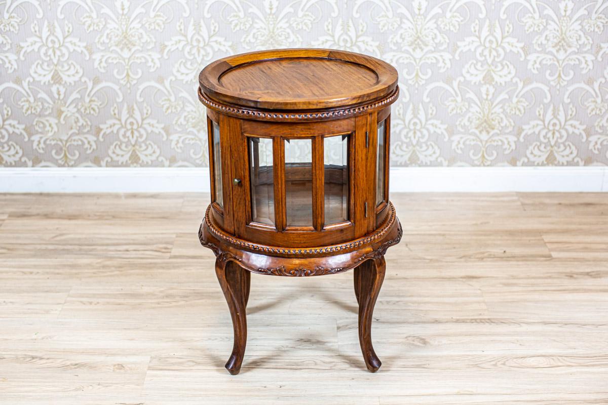 Prewar oak side table/liquor cabinet with tray

We present you an oak Rococo Revivial table manufactured before 1939.
This piece of furniture is of a cylindrical shape, placed on bent legs.
The section under the top is glazed and can be opened