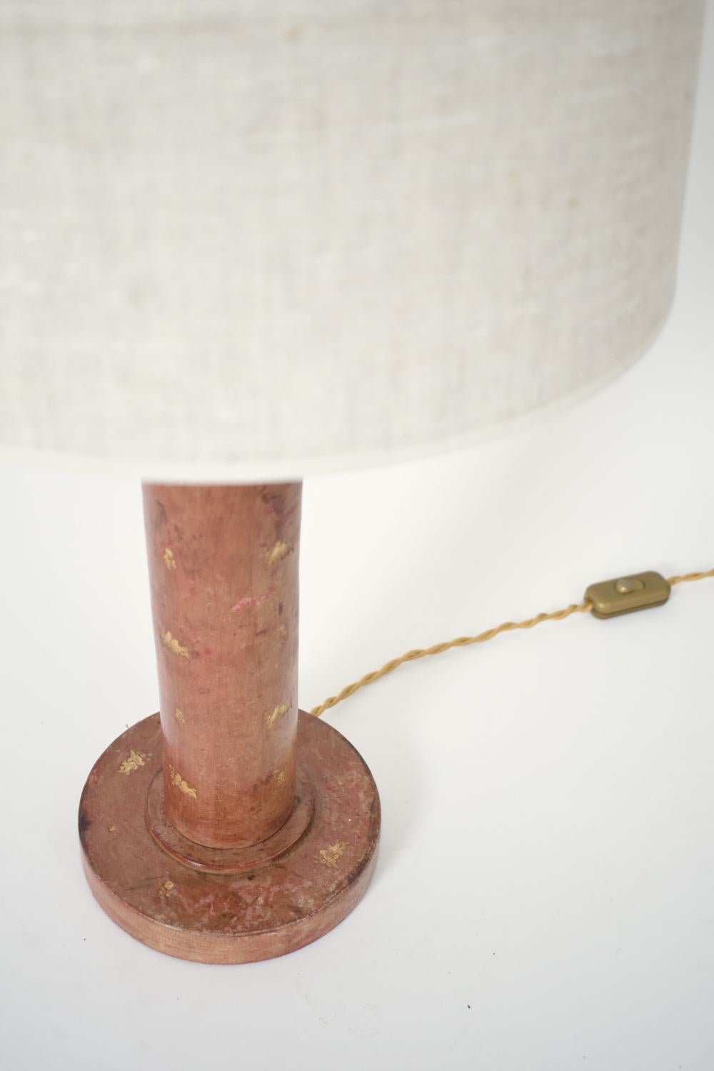 Cylindrical lamp base covered in leather with gold-stamped decoration of birds and flowers, in the style of Dupre Lafon and Hermes. France, 1940s. 