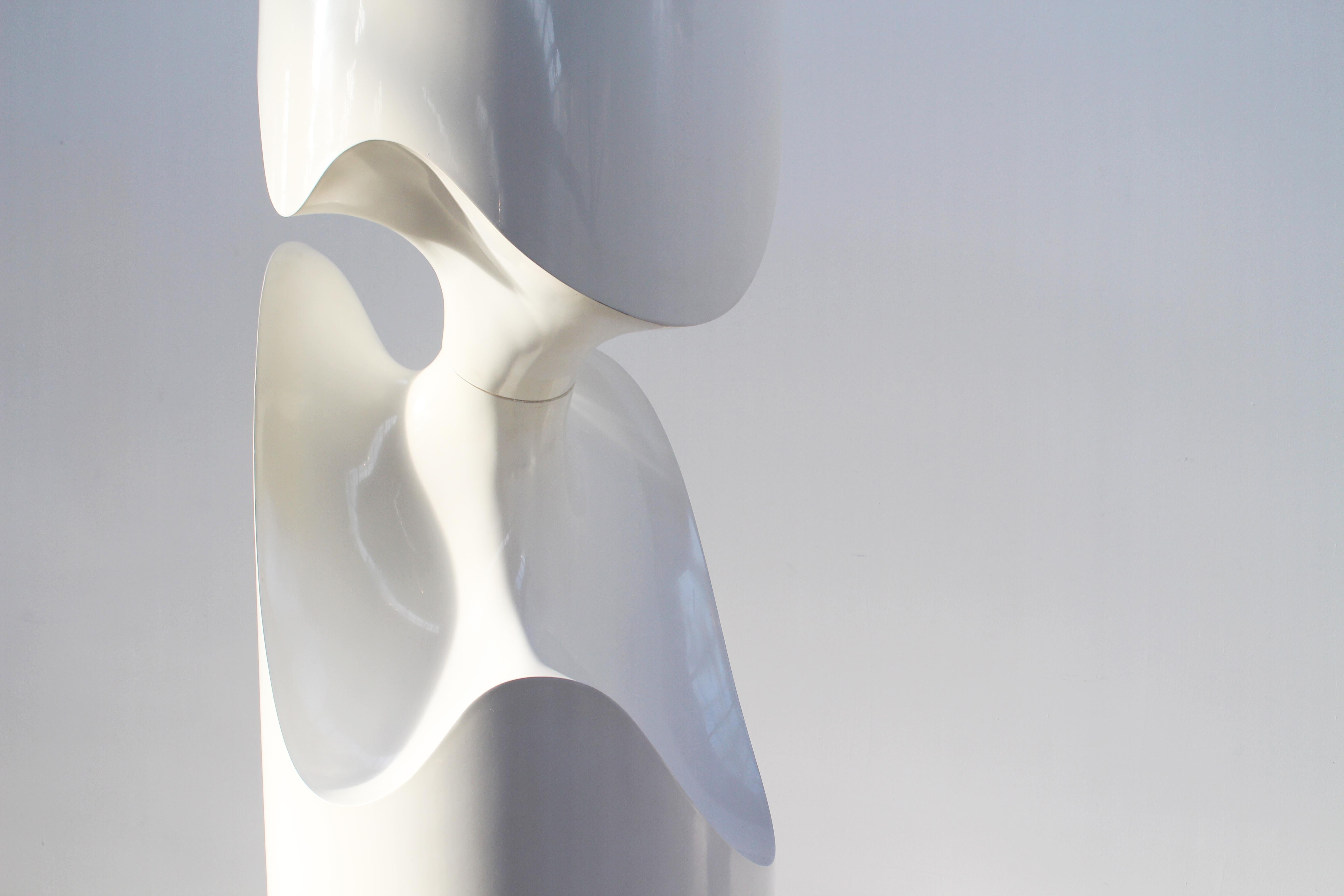 The white cylindrical TOTEM sculpture, produced in 1998 in France. 

The sculptors Simonnet: 

The couple looks for rational ways to create and invent shapes, to open fields of investigation which distance
themselves from the limitations of