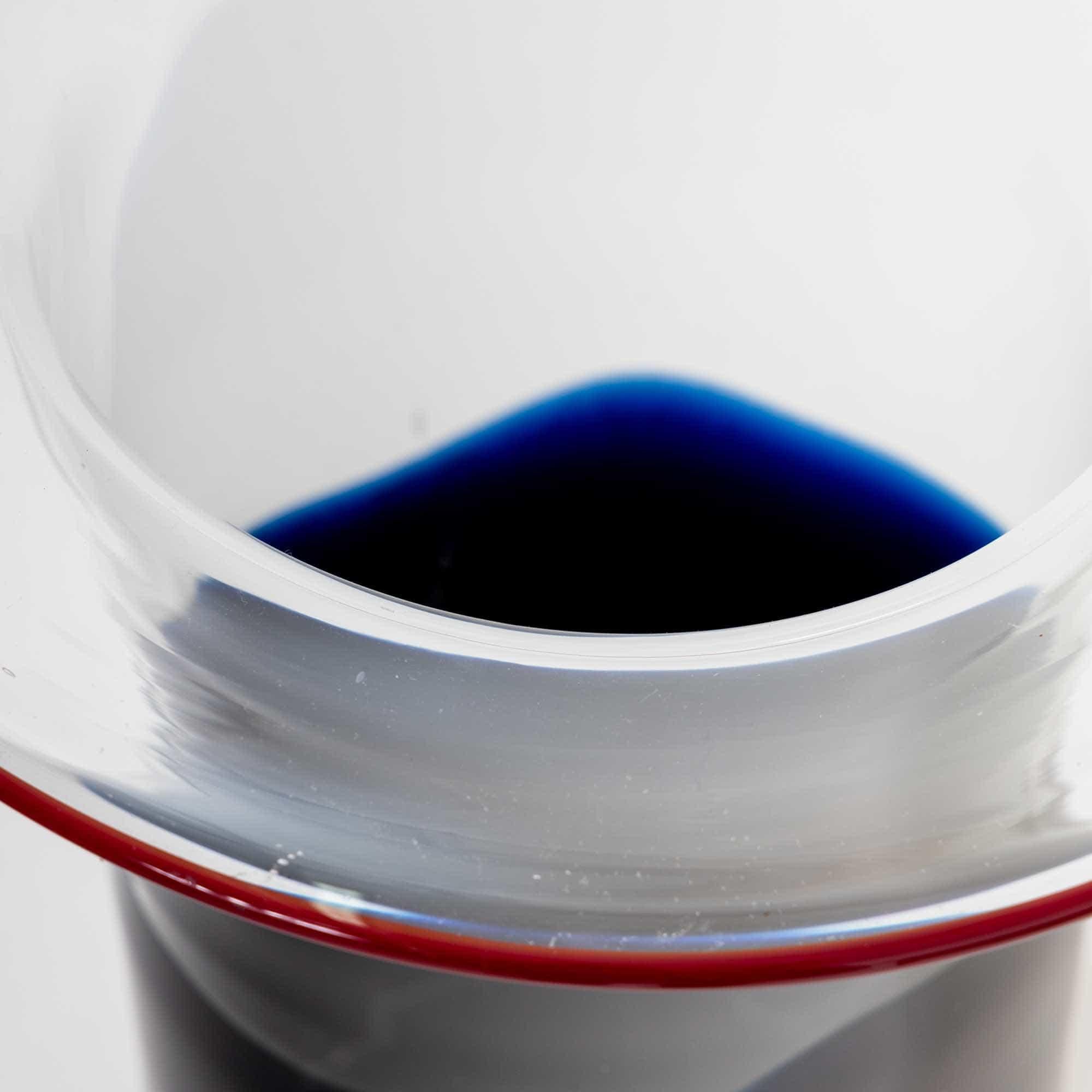 Große Vase aus Murano-Glas in zylindrischer Form. Das klare Glas ist am Rand rot abgesetzt und geht nach unten hin in dunkles Blau über.