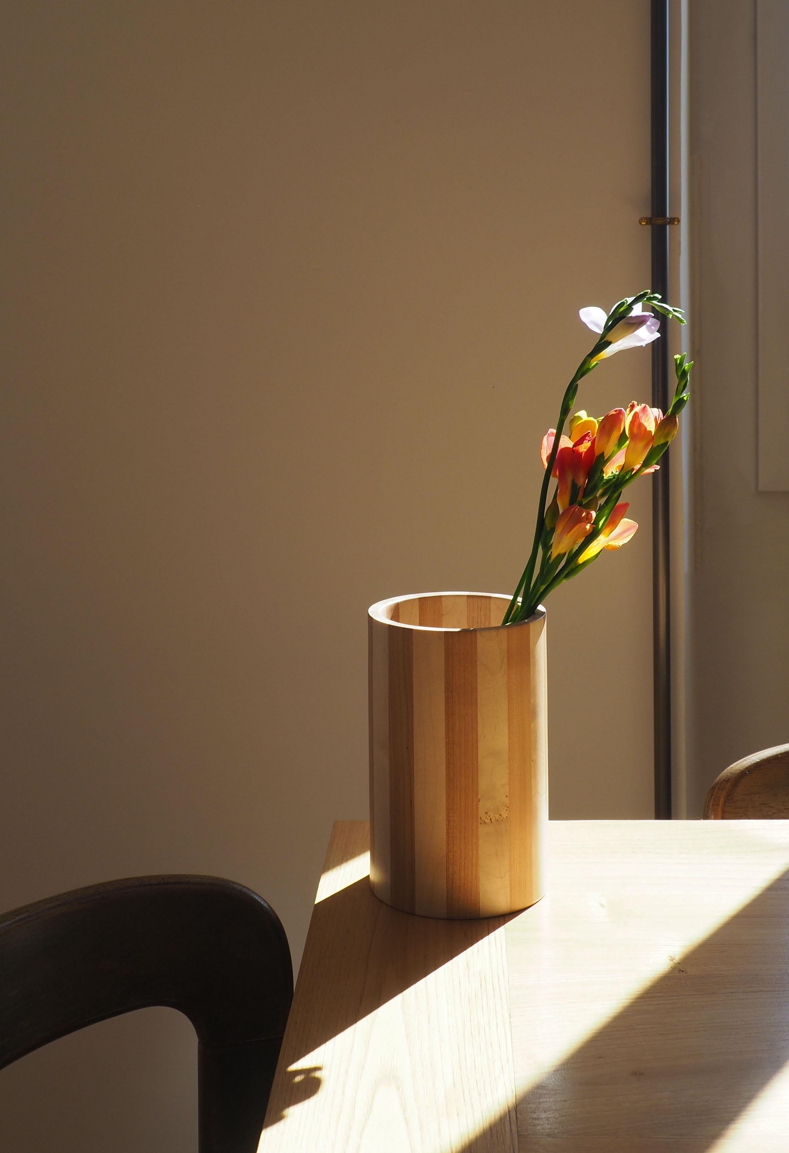 This cylindrical vase celebrates the graphic lines and the contrast of the essences. In maple and cherry, it was first assembled and then turned by Coralie Le Borgne in Lyon (France) and protected by hard oil. Sold with a glass vase to slide