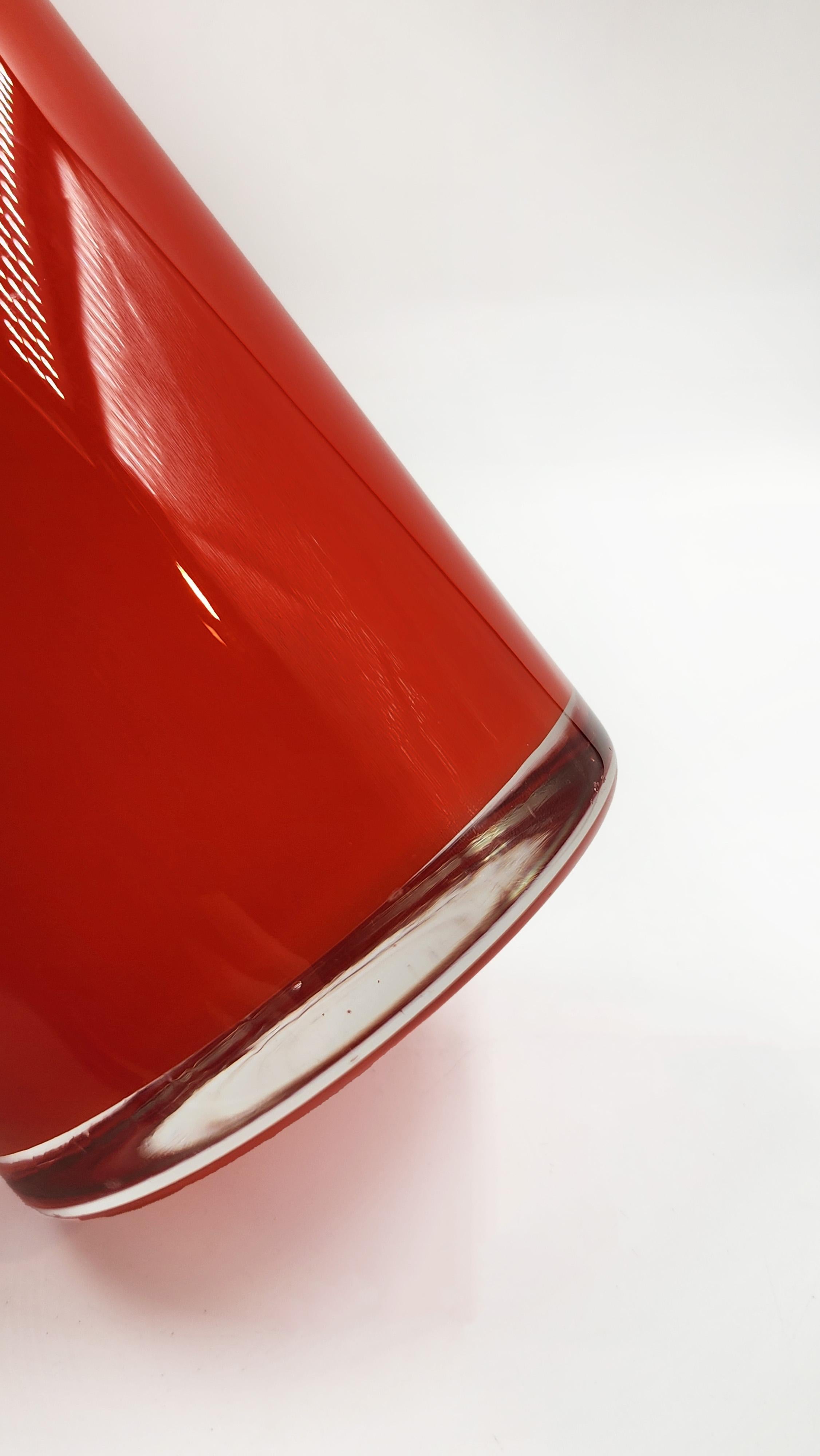 Artistic Glass Cylindrical Vase
This cylindrical glass vase, reminiscent of 1960s design, features a vibrant orange color with a slight tonal gradient. Its shape is simple and elongated, with a flat base and a smooth, vertical body. The glass finish