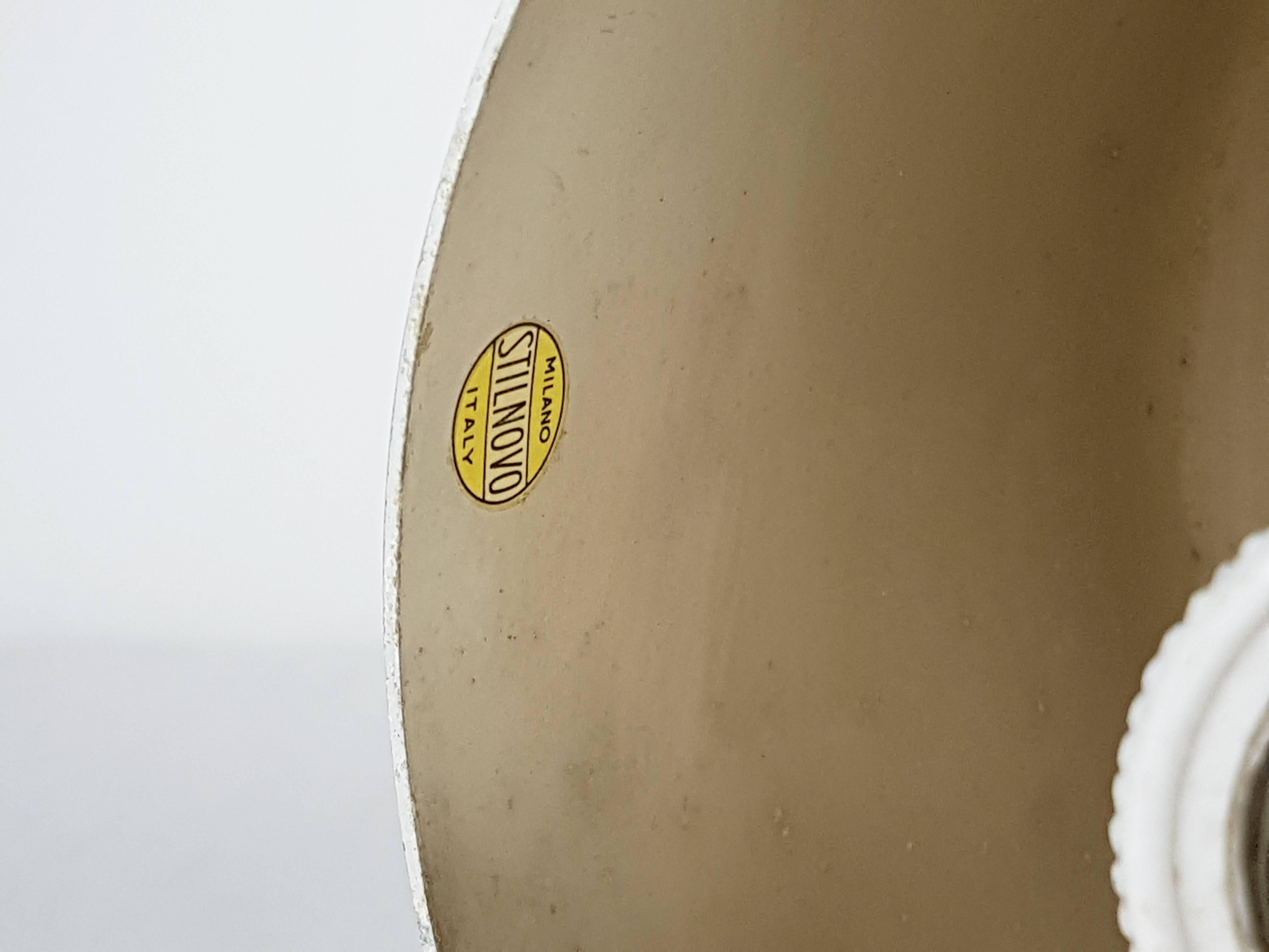 Ce plafonnier cylindrique est composé d'un corps en aluminium peint en argent et noir et d'un abat-jour en verre sablé blanc. Il a été produit en Italie par Stilnovo, vers 1950. Etiquette jaune Stilnovo à l'intérieur du corps. La lampe reste en bon