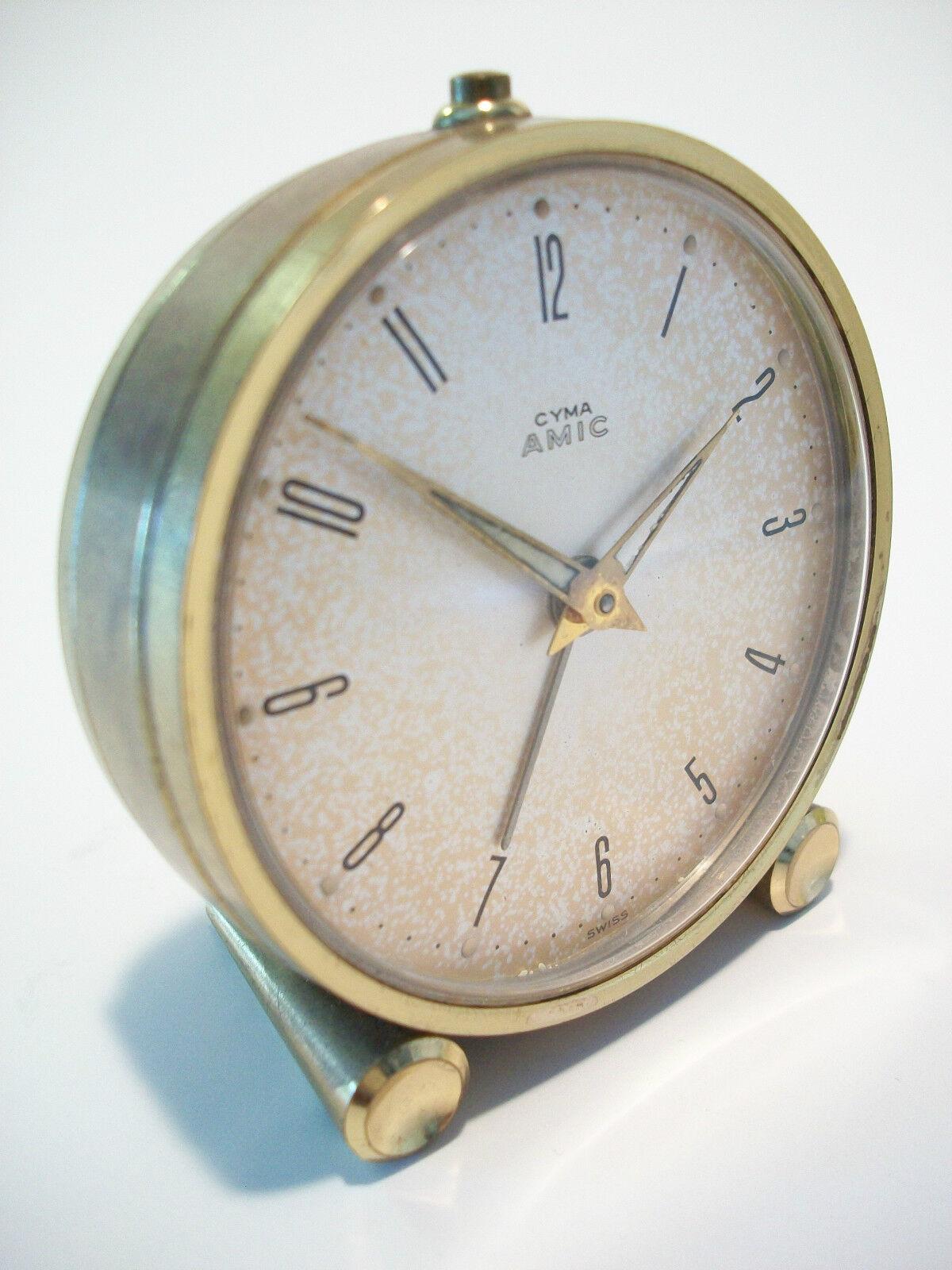 CYMA WATCH COMPANY - Brass alarm clock - Swiss made - circa 1950's.  Features include - manual wind - alarm stop on top and back - 11 jewels - separate dials for adjusting the time and the alarm - glow in the dark hands with reference marks above