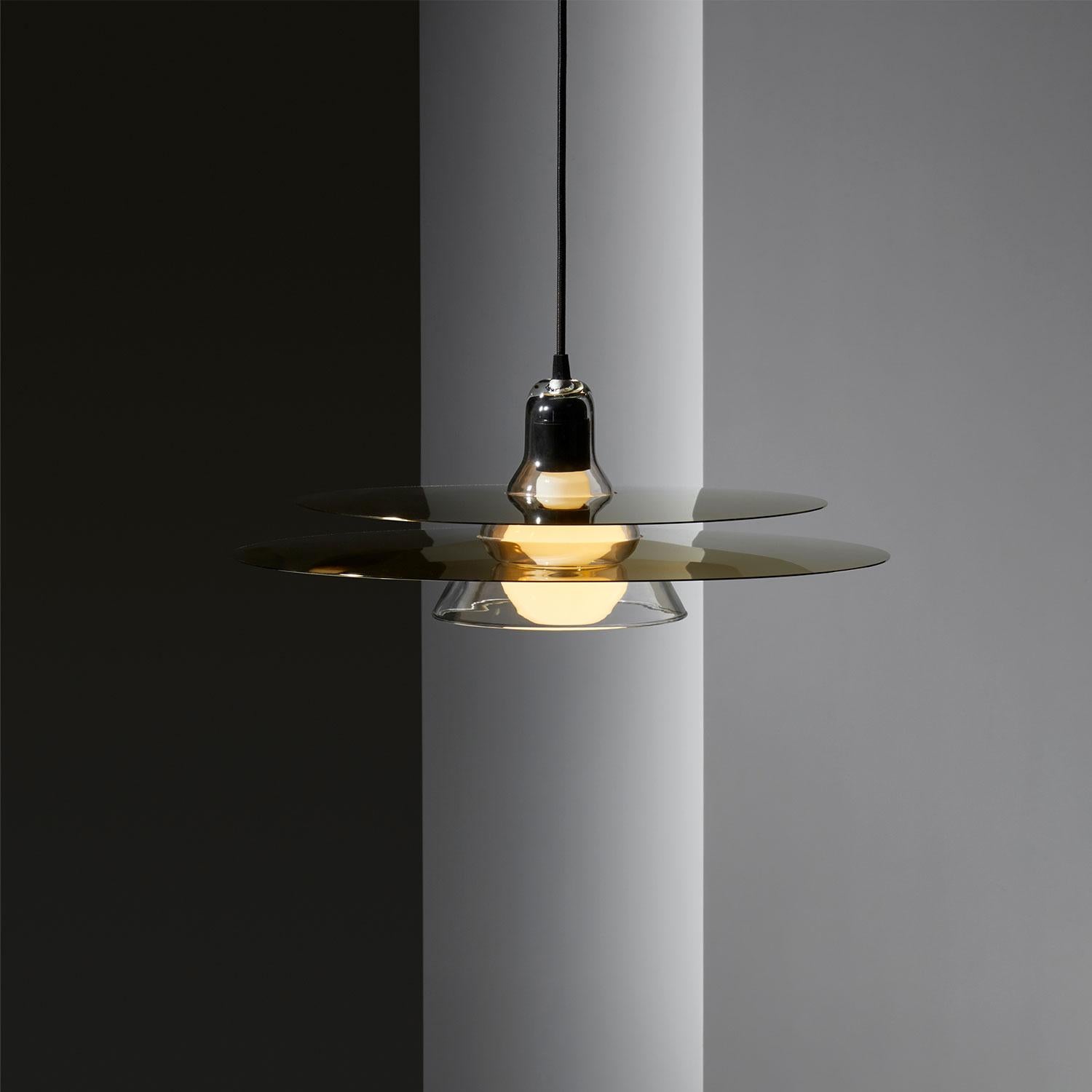Cymbal pendant lamp by Jean-Baptiste Souletie
Dimensions: D 47 x H 15 cm
Materials: Painted solid steel 


Cymbal is a simple yet intriguing pendant lamp. Cymbal shaped disks of black, chrome or gold steel diffract the light in every direction