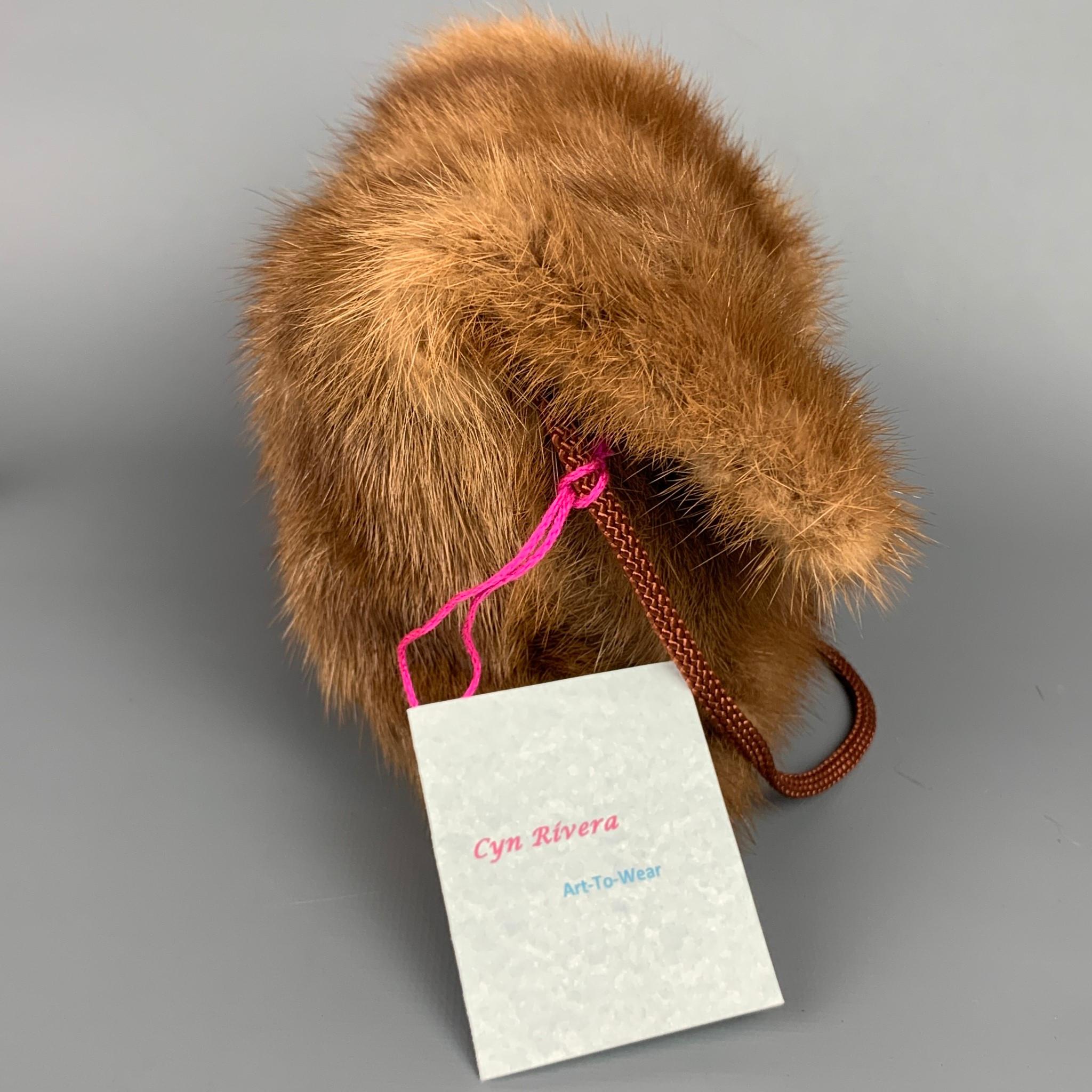 CYN RIVERA handbag comes in a tan mink fur with a floral liner featuring a shoulder strap, inner pocket, and a single button closure. Handmade. 

New With Tags.
Original Retail Price: $250.0

Measurements:

Length: 8.5 in.
Width: 1 in.
Height: 6.5