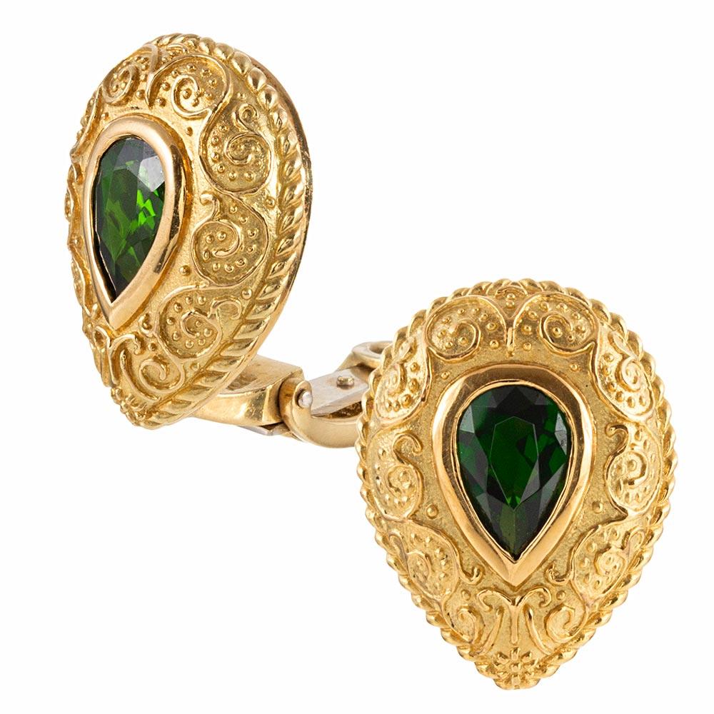 Made of 18 karat yellow gold and decorated with a modernized granulation reminiscent of Etruscan Revival, these teardrop shaped ear clips are each set with a pear tsavorite garnet. Green garnets are uncommon and even more so difficult to find in