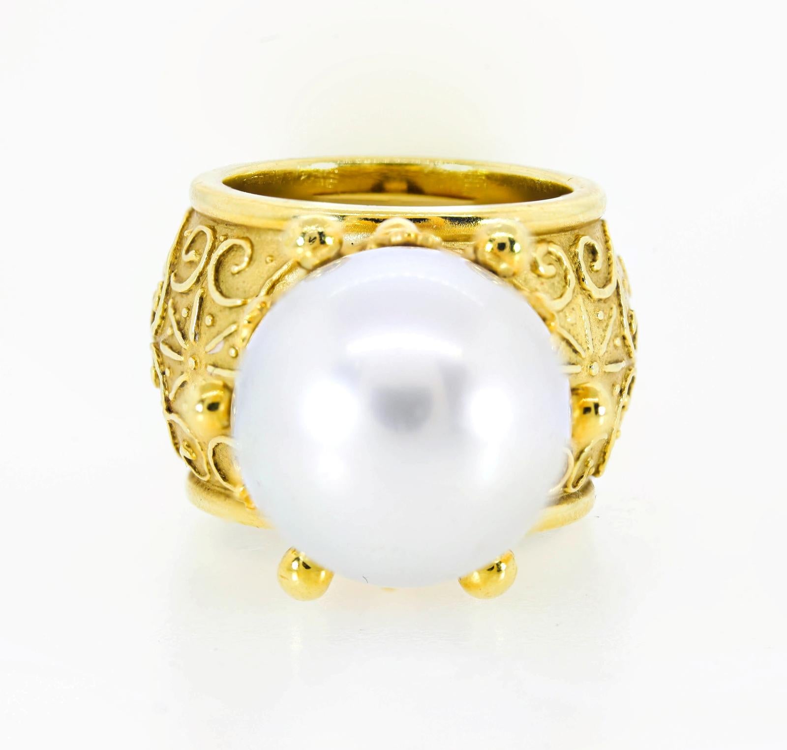 From Los Angeles designer Cynthia Bach this distinctive 18KT yellow gold ring.   It features a lustrous 14.65 mm South Sea Pearl nestled in her iconic detailed crown design.  The setting is stunningly adorned with raised scroll work and engraving. 