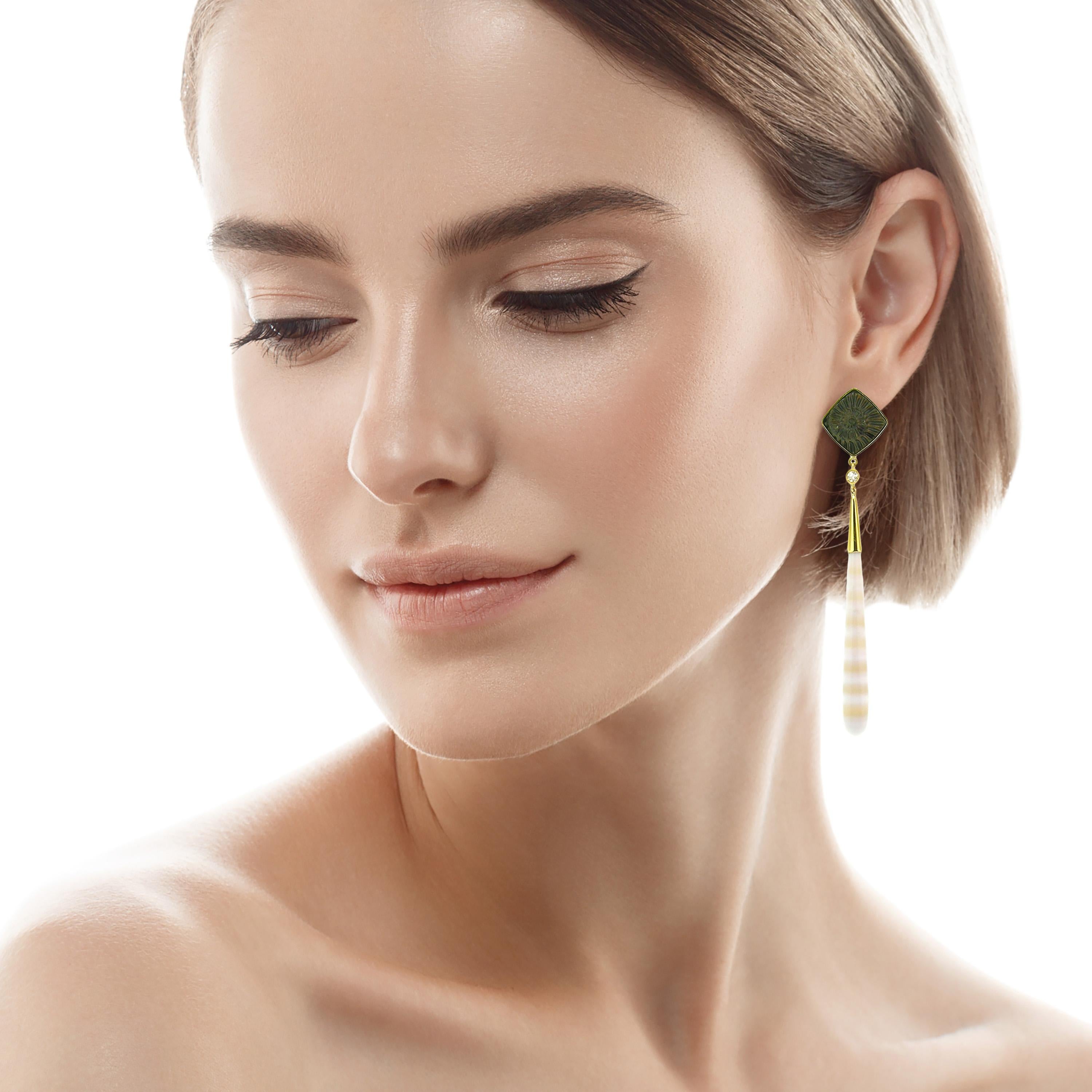 These sophisticated earrings feature fossil imprints of ancient ammonites, which have mineralized into pyrite. The drops are German-carved agate with alternating bands of creamy white and translucent peach. The rich bronze color of the pyrite and