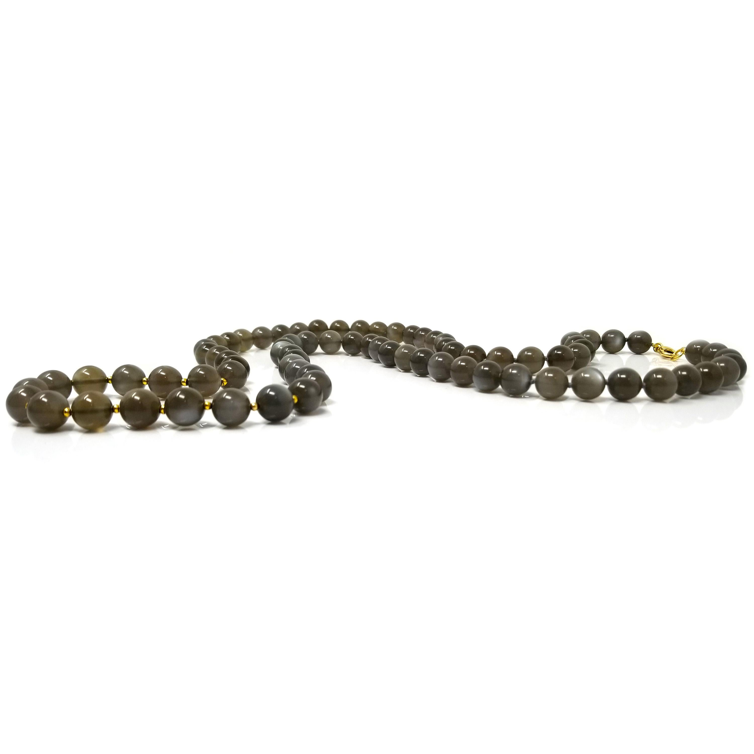 Perlenhalsketten aus schönen Edelsteinen sind eine einfache Möglichkeit, ein Outfit aufzuwerten. Diese ätherischen Mondsteine haben eine satte taupegraue Farbe und eine bezaubernde Adulareszenz. 

Einige zarte 18-karätige Akzente verleihen der Kette