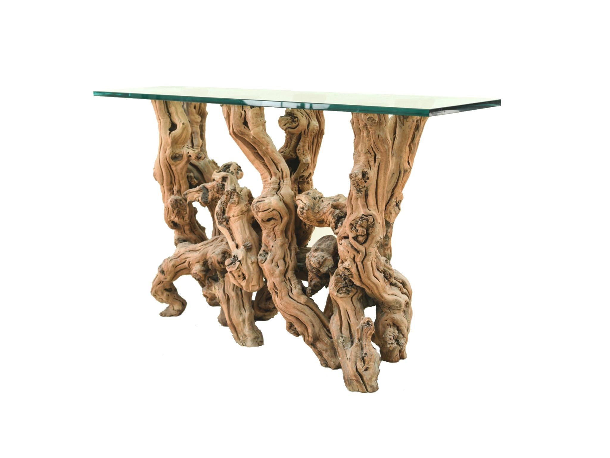 An exquisite console table comprised of a transformed cypress root base and a transparent glass top. We love this table for its organic quality and dynamic lines. The base is beautifully gnarled while pared down and simple. The glass top is minimal