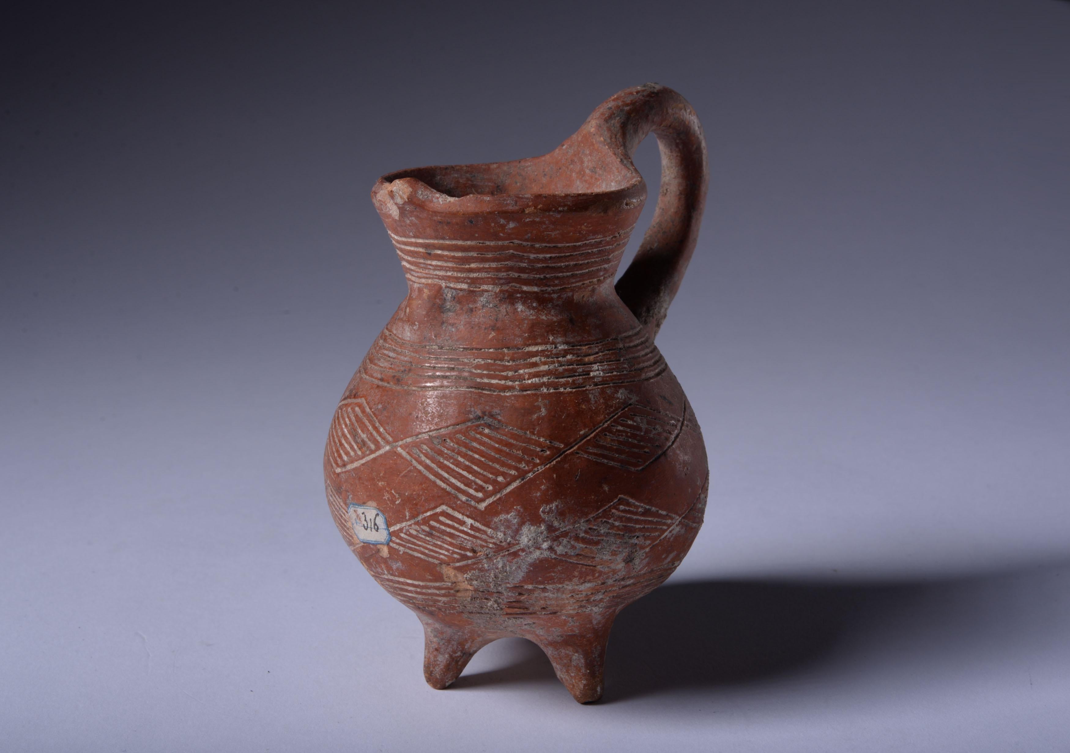 Cypriot red polished ware tripod pot
Early bronze Age, circa 2100-1800 B.C.
Terracotta
With old labels reading ‘Chypre’ and ‘No. 316’
Measure: height: 9 cm

This tripod vessel from Ancient Cyprus is a charming testament to the talent and