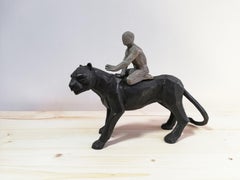 Passeur d'Ames bronze sculpture of a boy riding on a black panther's back 