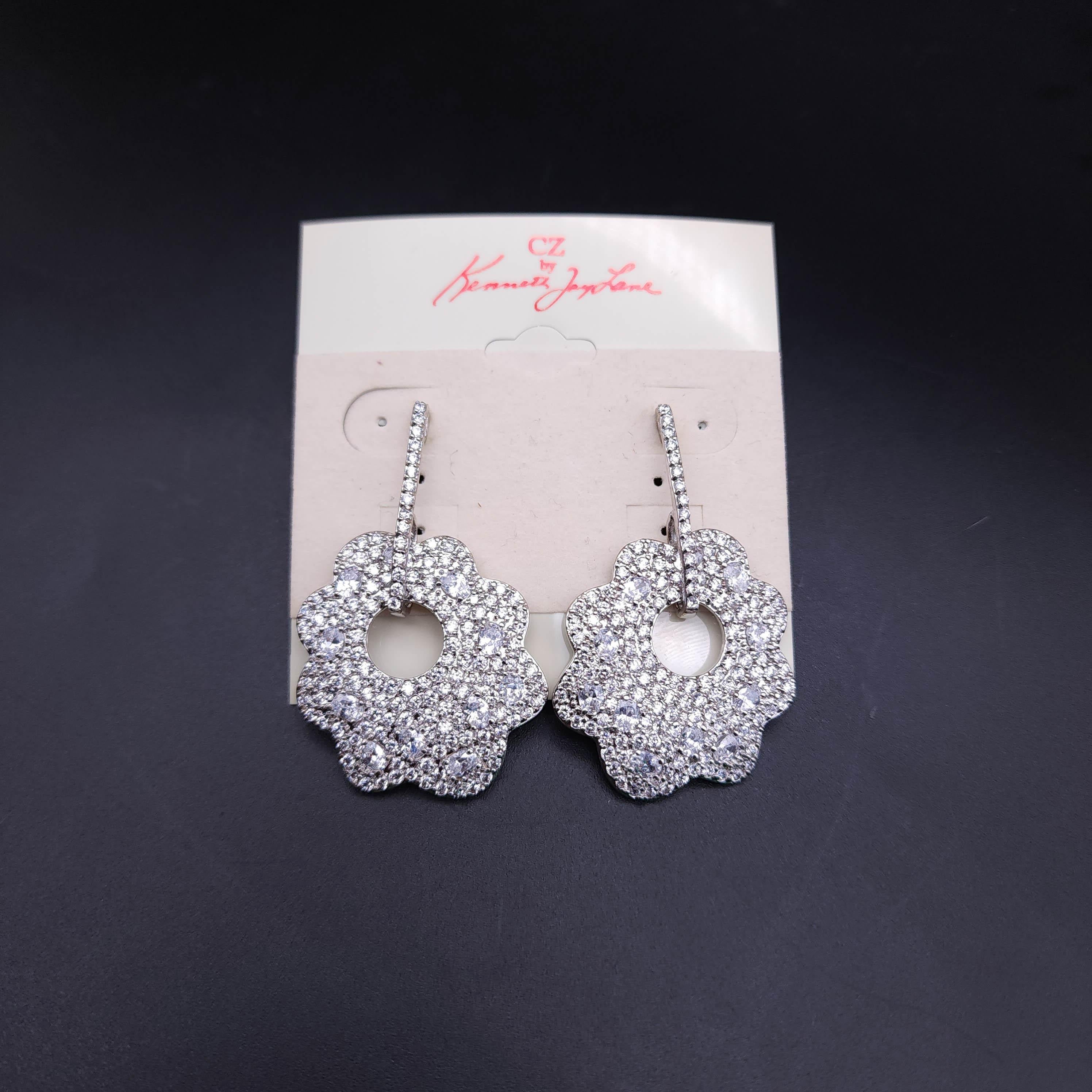 Add a touch of dazzling elegance to your jewelry collection with the Kenneth Jay Lane pave clear cubic zirconia crystal dangle floral earrings. These exquisite earrings feature a dazzling display of pave-set clear cubic zirconia crystals,