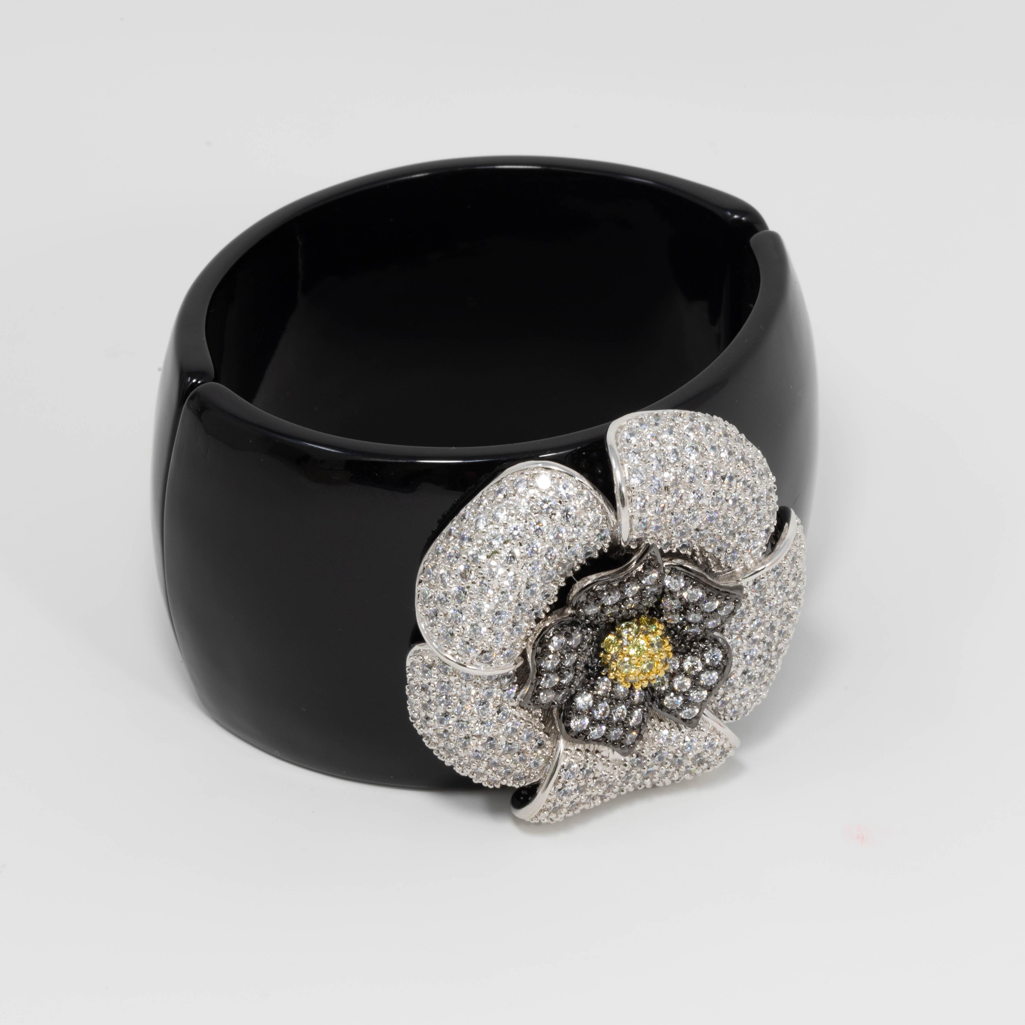 Floral-themed bracelet by Kenneth Jay Lane. Features a flower decorated with clear and lemon cubic zirconia crystals, set on a wide black acrylic band.


Hallmarks: none

Inner circumference: 6.75 in / 17 cm
Inner diameter at widest part: 2.4 in /