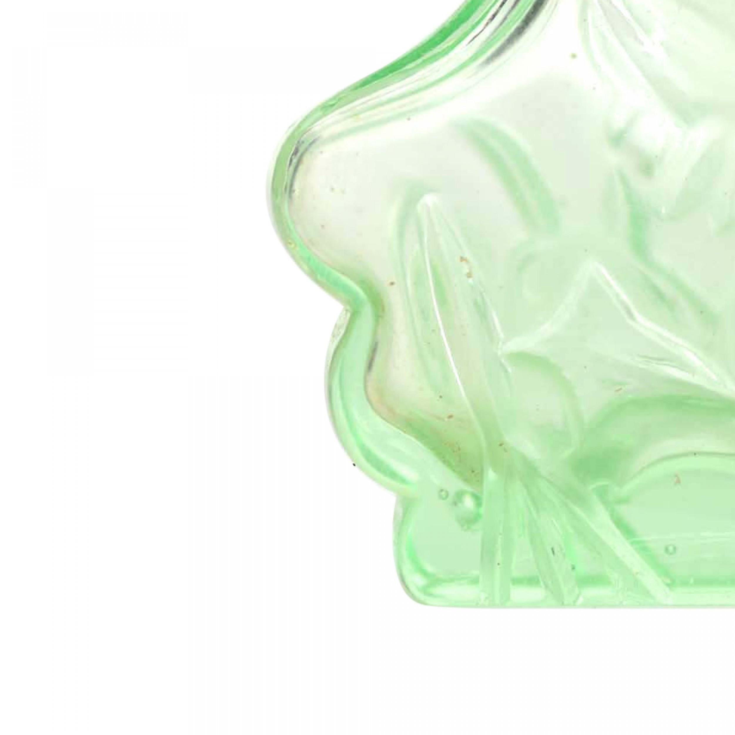 Bottiglia di profumo in vetro verde stile Art Deco cecoslovacco con un disegno floreale dentellato e un tappo a diadema in vetro trasparente con fiori in rilievo.