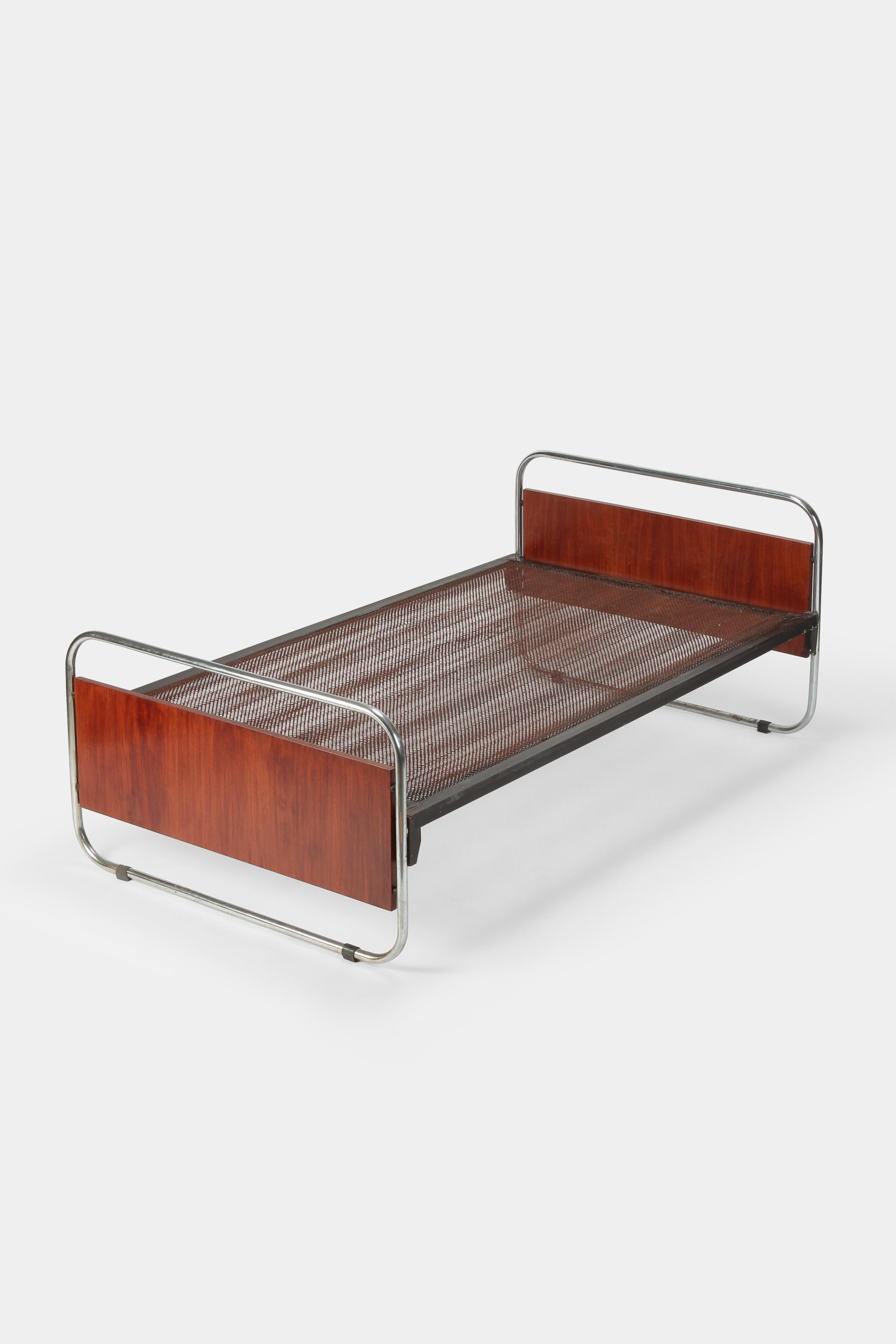 Unique Bauhaus bed manufactured in the 1930s in Czech. The sides are made of two teak wood veneered boards surrounded by chrome steel frames. Attached to them is a black lacquered grid with striking patina.