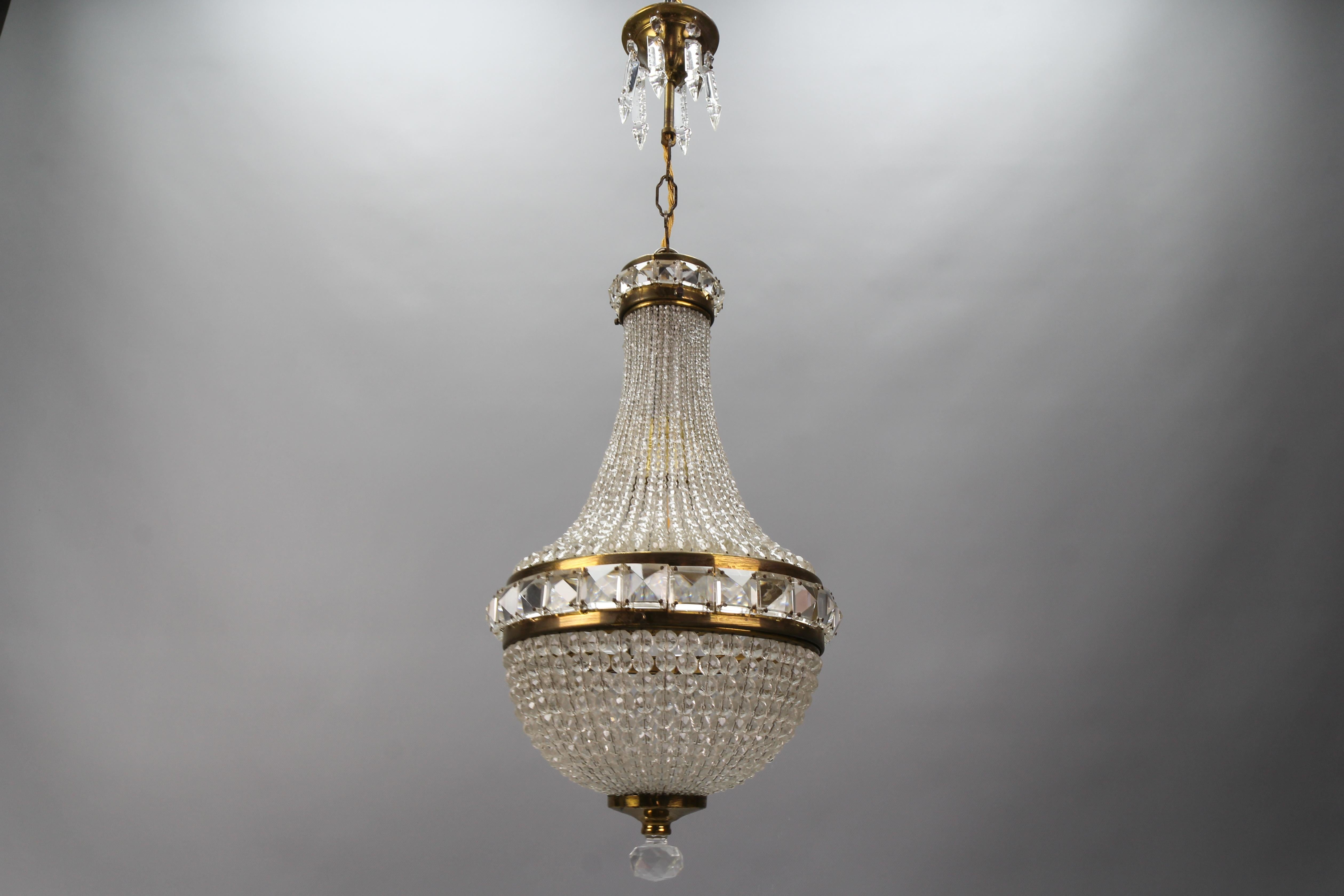 This absolutely adorable Czech crystal beaded Empire-style dome chandelier pendant from circa the 1950s consists of strands of crystal cut balls sizing from small to big. Ballroom style, the brass frame features large square prisms in the center and