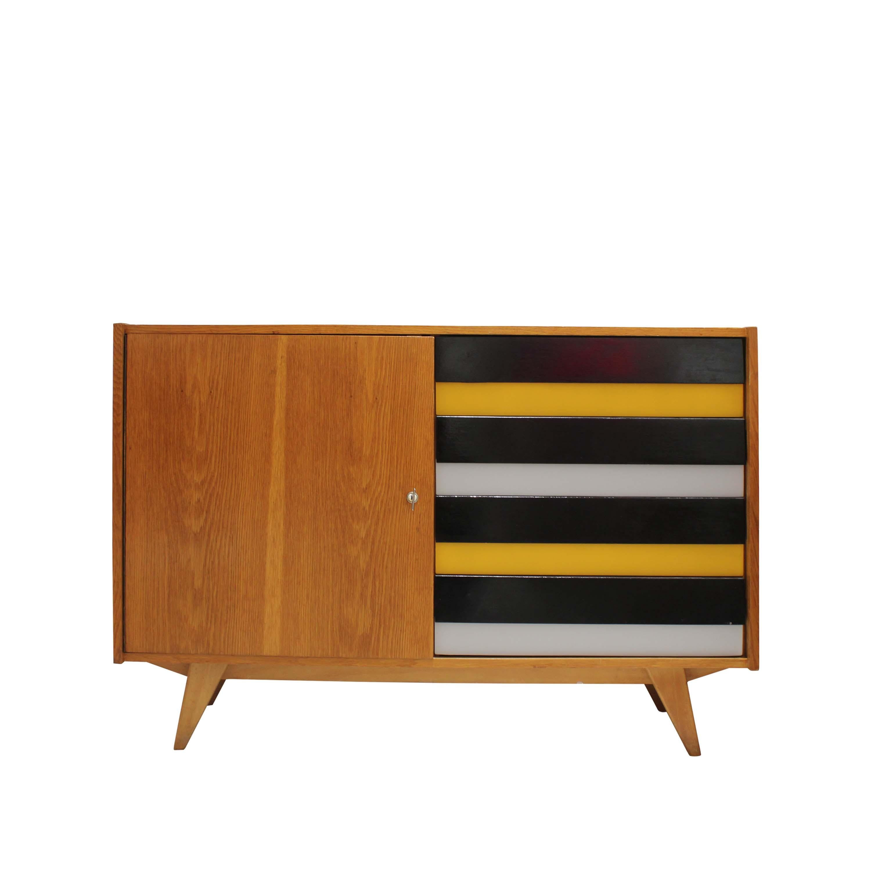 Mid-century oak sideboard made in Czechoslovakia in the 1960s. This elegant piece features four lacquered drawers in striking horizontal bands of black, yellow, and grey, positioned on the left side. The door on the right reveals generous storage