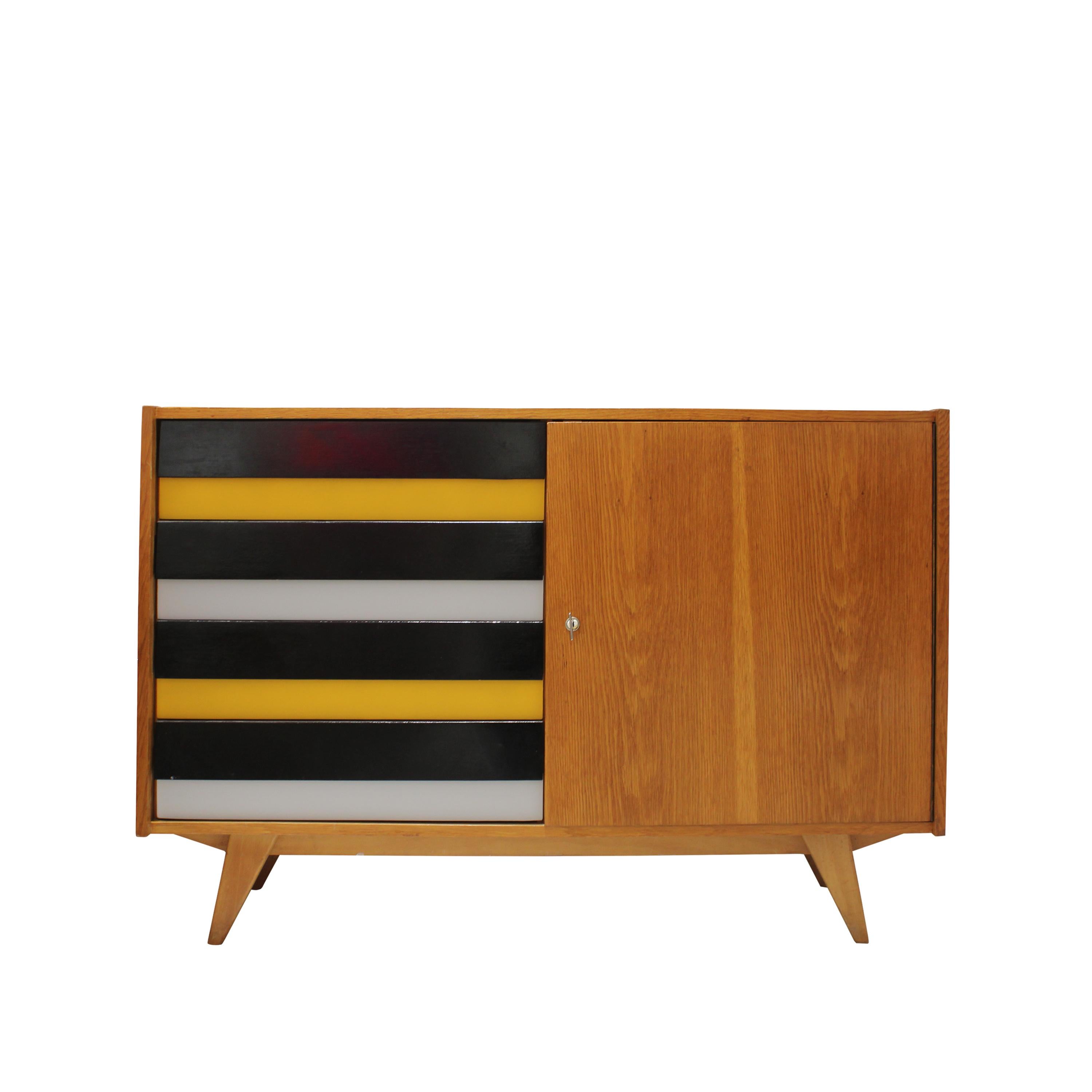 Mid-century oak sideboard made in Czechoslovakia in the 1960s. This elegant piece features four lacquered drawers in striking horizontal bands of black, yellow, and grey, positioned on the left side. The door on the right reveals generous storage