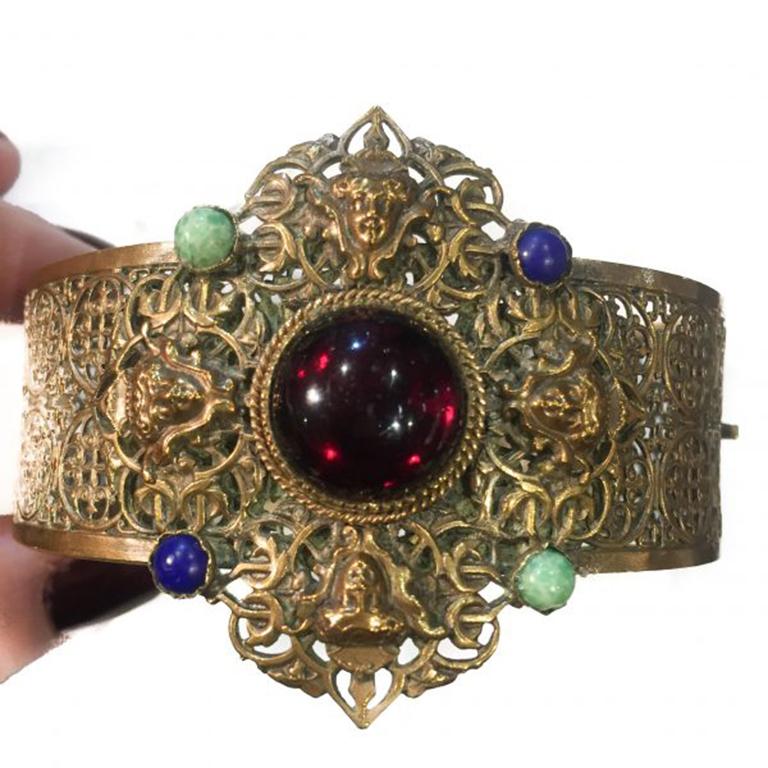 A lovely Filigree metalwork Czech Vintage Bangle made around 1920-30. This Czech Vintage Bangle oozes detail and the detailing of the faces and the stones on top of the workmanship in the filigree are captivating. Coming up towards 100 years old